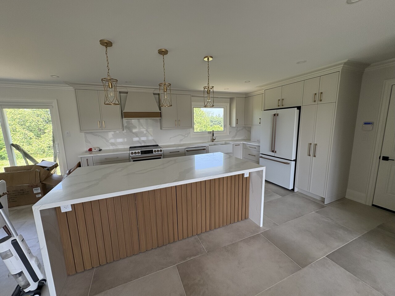 Construction worker wearing a yellow hard hat and gloves, writing notes on a notepad in a busy workshop.