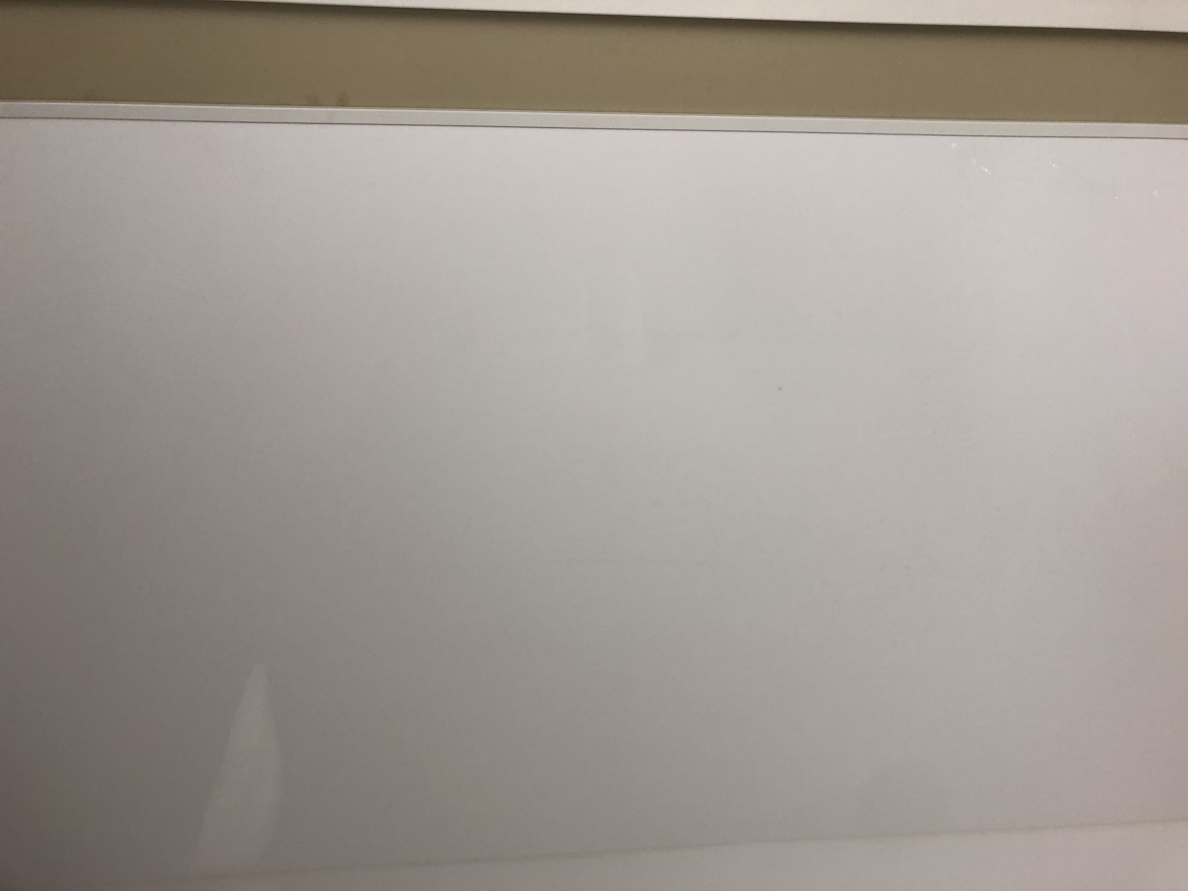 Modern bathroom with gray tiles, glass shower, wall-mounted vanity, large mirror, and natural light from a window.