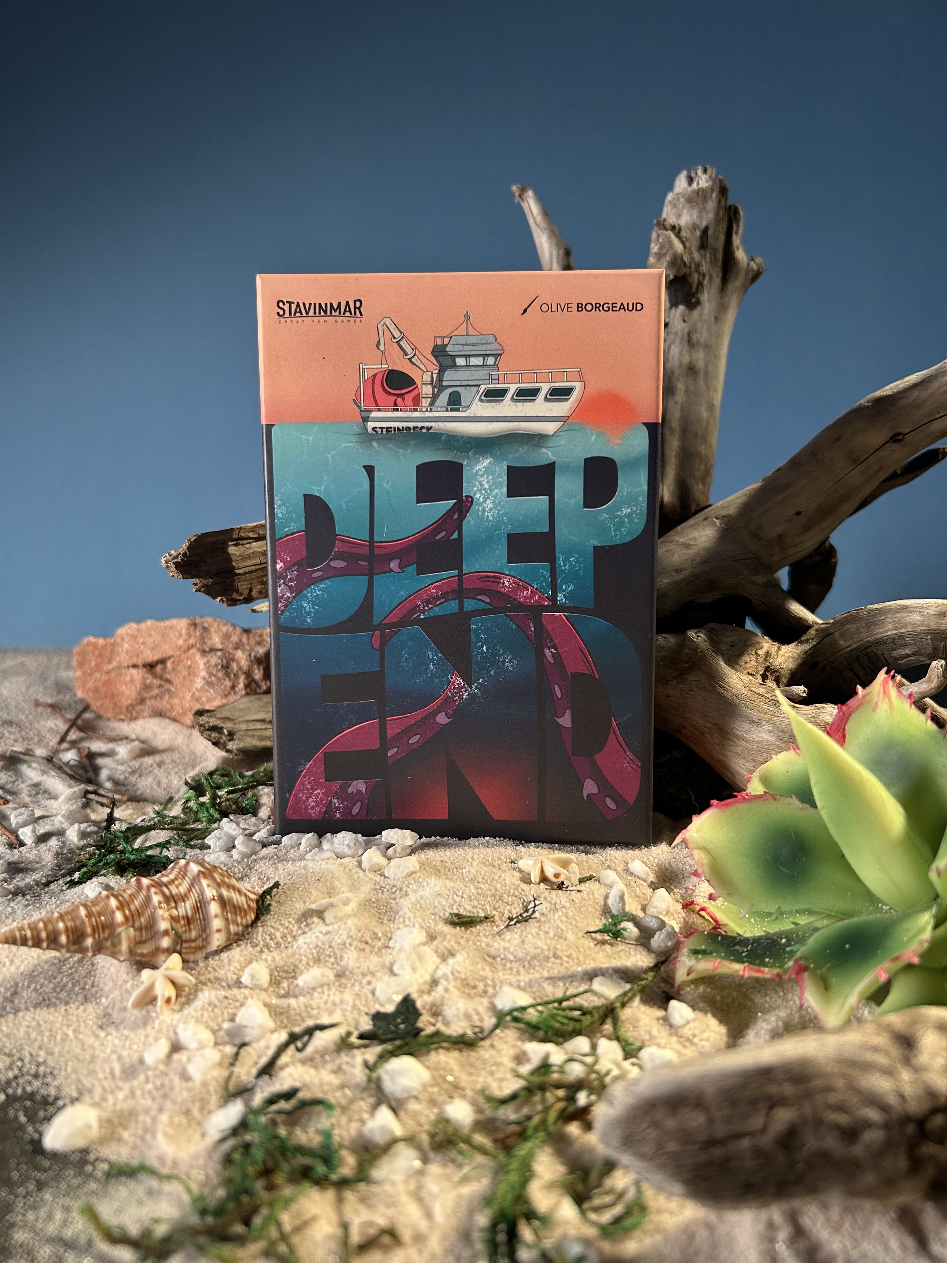 Board game setup on a wooden table featuring colorful cards, tokens, and the central title card labeled 'Stavimar'.