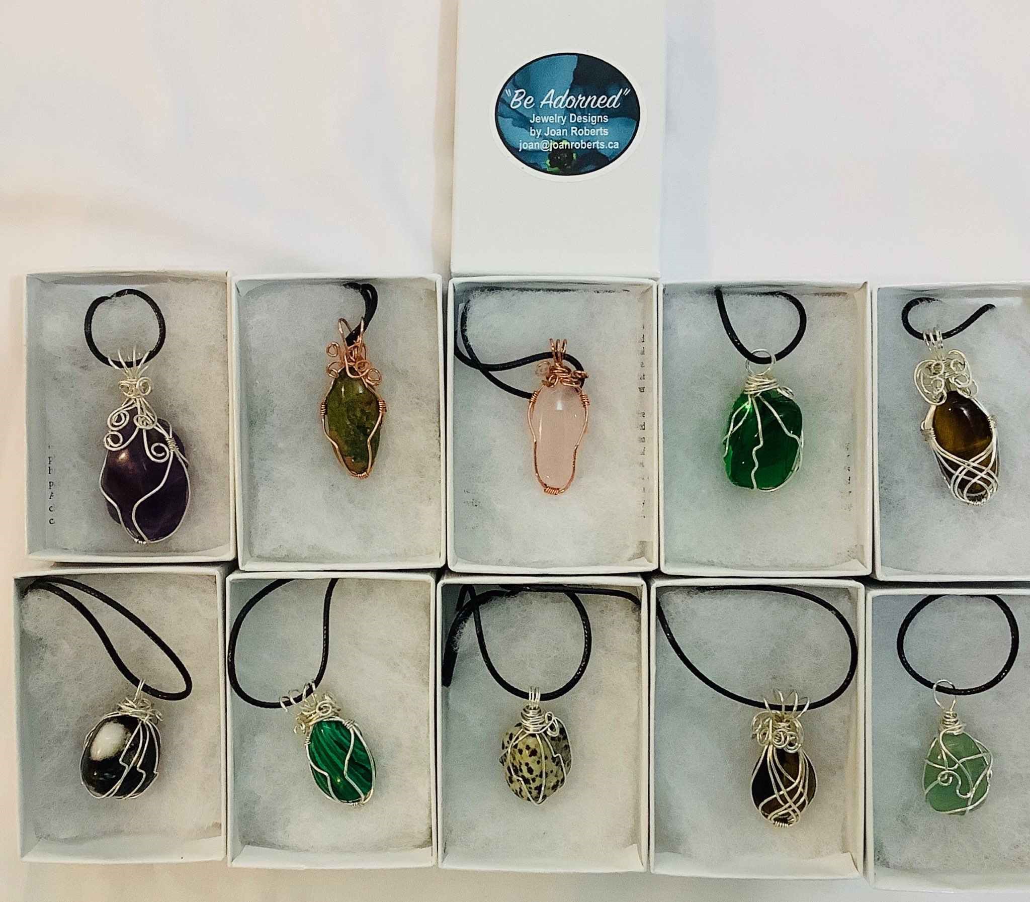 Natural stone, individually wire wrapped in silver coated copper.  Stone from top to bottom are:  Amethyst, unakite, rose quartz, green obsidian, tiger's eye, snow flake obsidian, malachite, dalmation, tiger's eye, and adventurine.  Each stone comes with a gif box.  Cost $40.00 each.