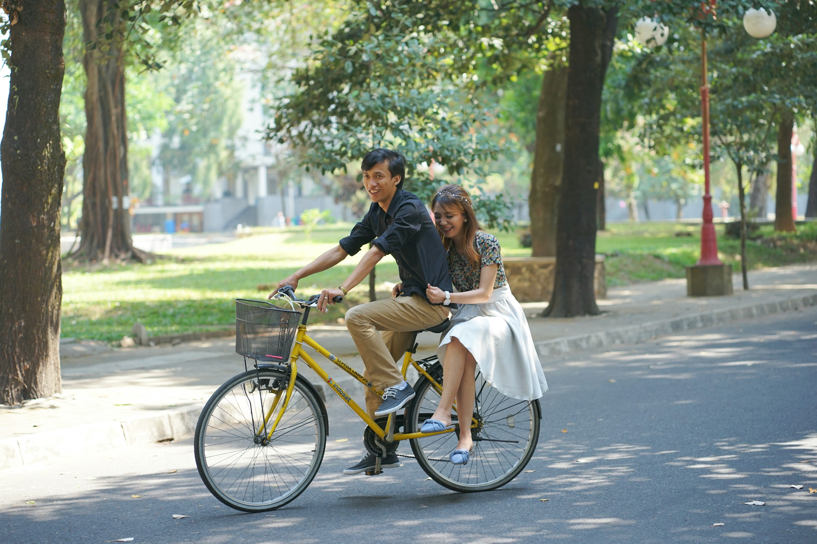 a man and a woman riding a bike together
