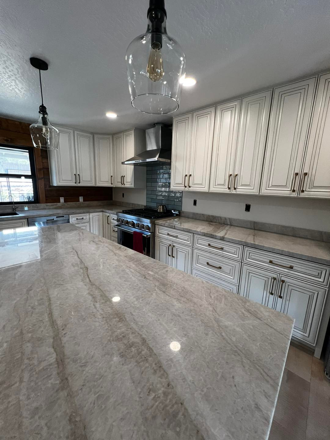 Spacious Kitchen Island with Marble Countertop and Pendant Lighting