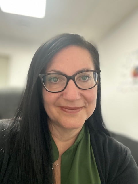 Vibrant flower garden with colorful blossoms, lush green grass, and elegant lamp post under tree shade.