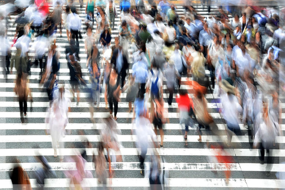 A blurry image of people walking on a busy crosswalk