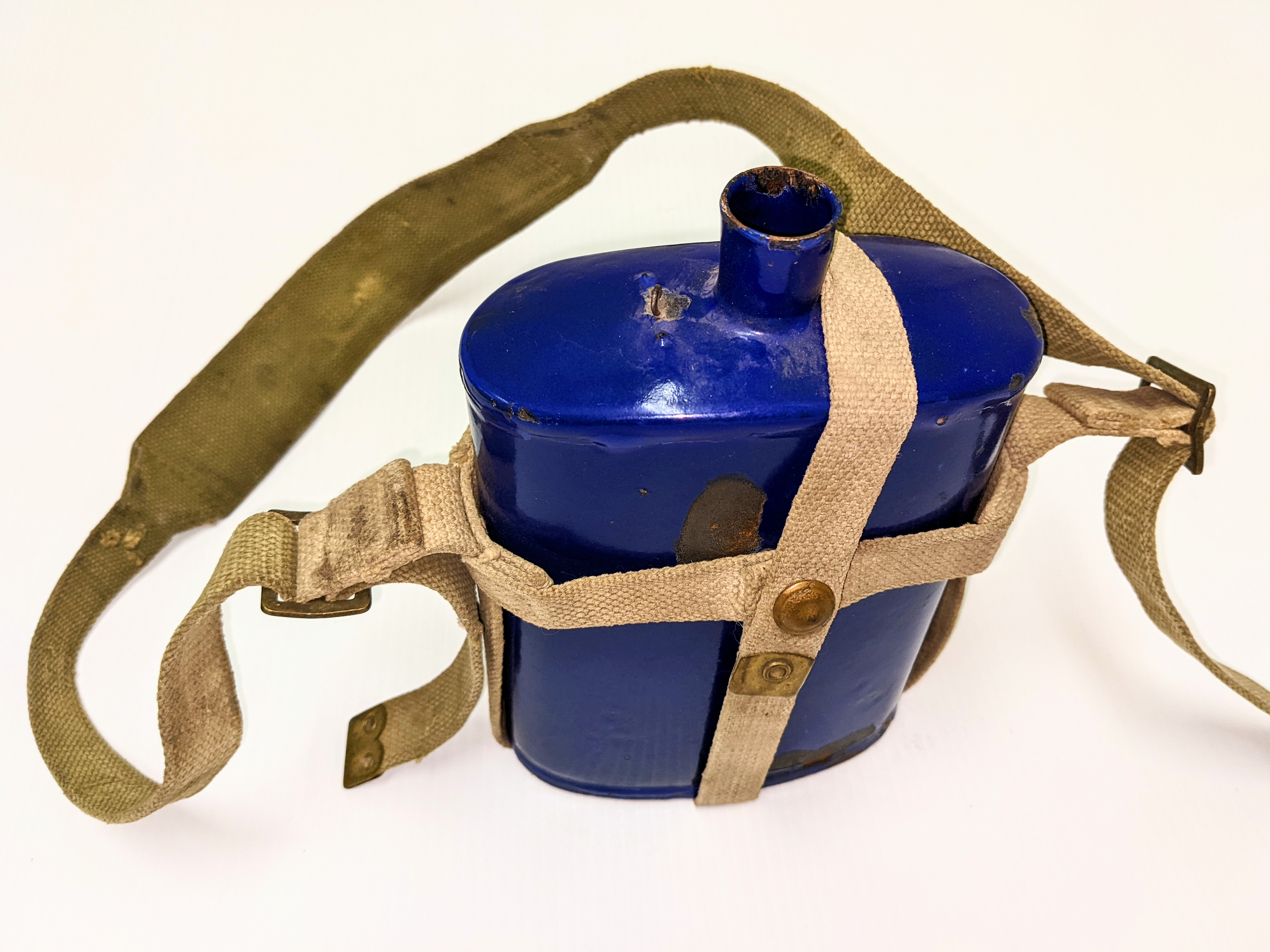 This is a Canadian WWII standard issue cobalt blue enamel waterbottle. The style of bottle was common amongst allied forces but small details such as the loop on the shoulder used to hold on the stopper (Missing) and design of the canvas carrying straps indicate it is Canadian made. It resides in the Eek, Marilyn Collection and was likely used by her Great Uncle Alfred During his years in service from 1943-1946.
03/01/2022
995.5.9 / Eek Marilyn
