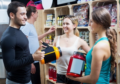 Group Of Young Adults Discussing Bodybuilding Supplements