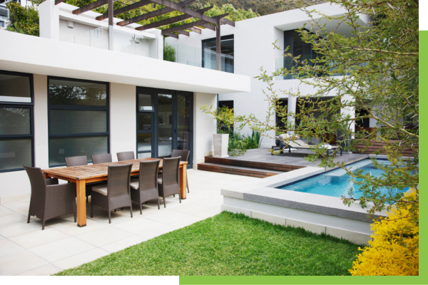 Dining area next to modern house and swimming pool