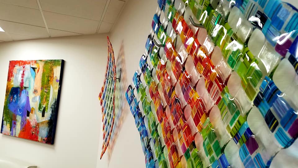 Orange classic sports car parked in a modern indoor garage, featuring custom gold rims and a front splitter.