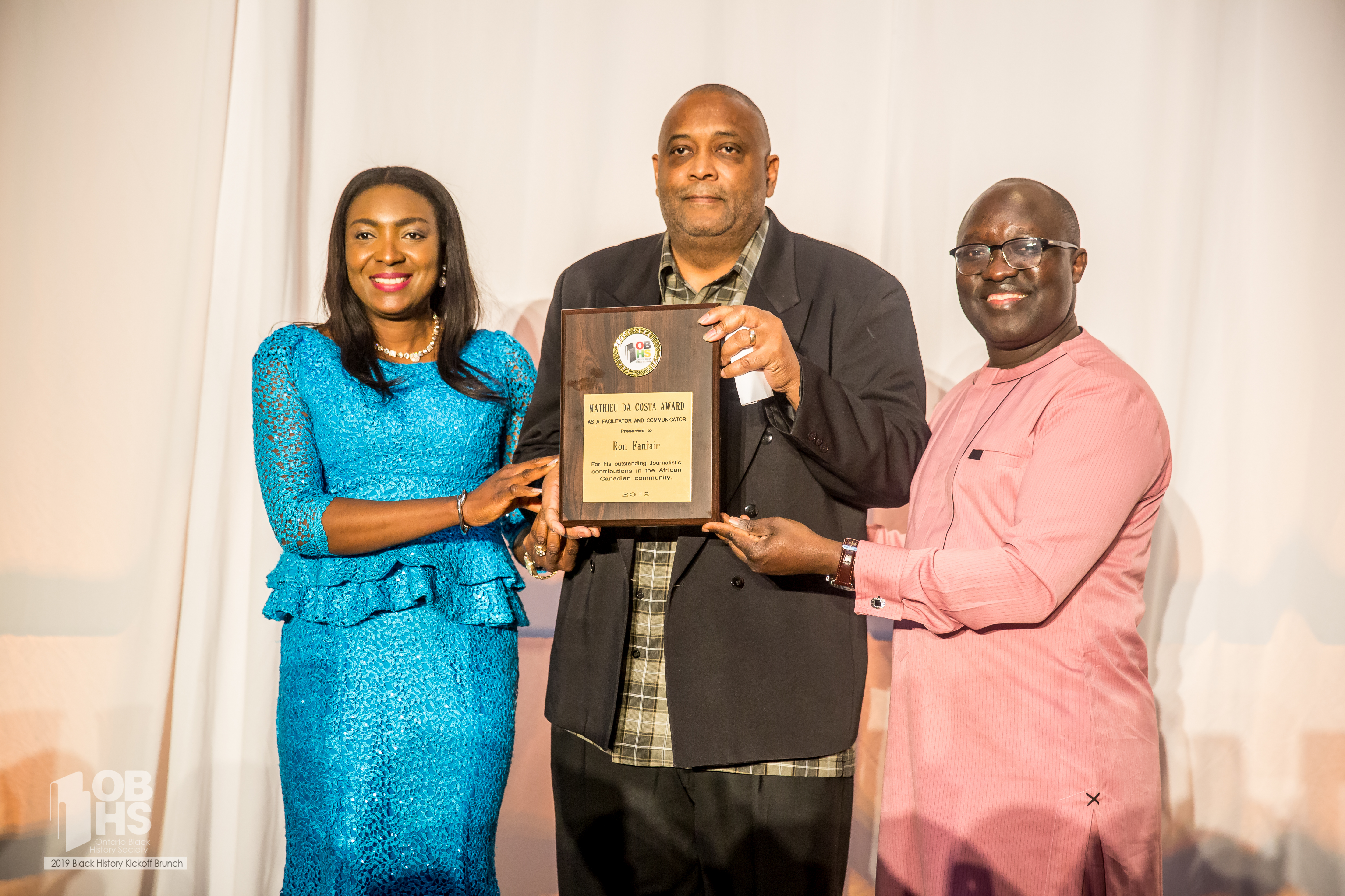 Patricia Bebia Mawa and Moses Mawa present award winner Ron Fanfair with his plaque- photo by www.sayhilondon.com