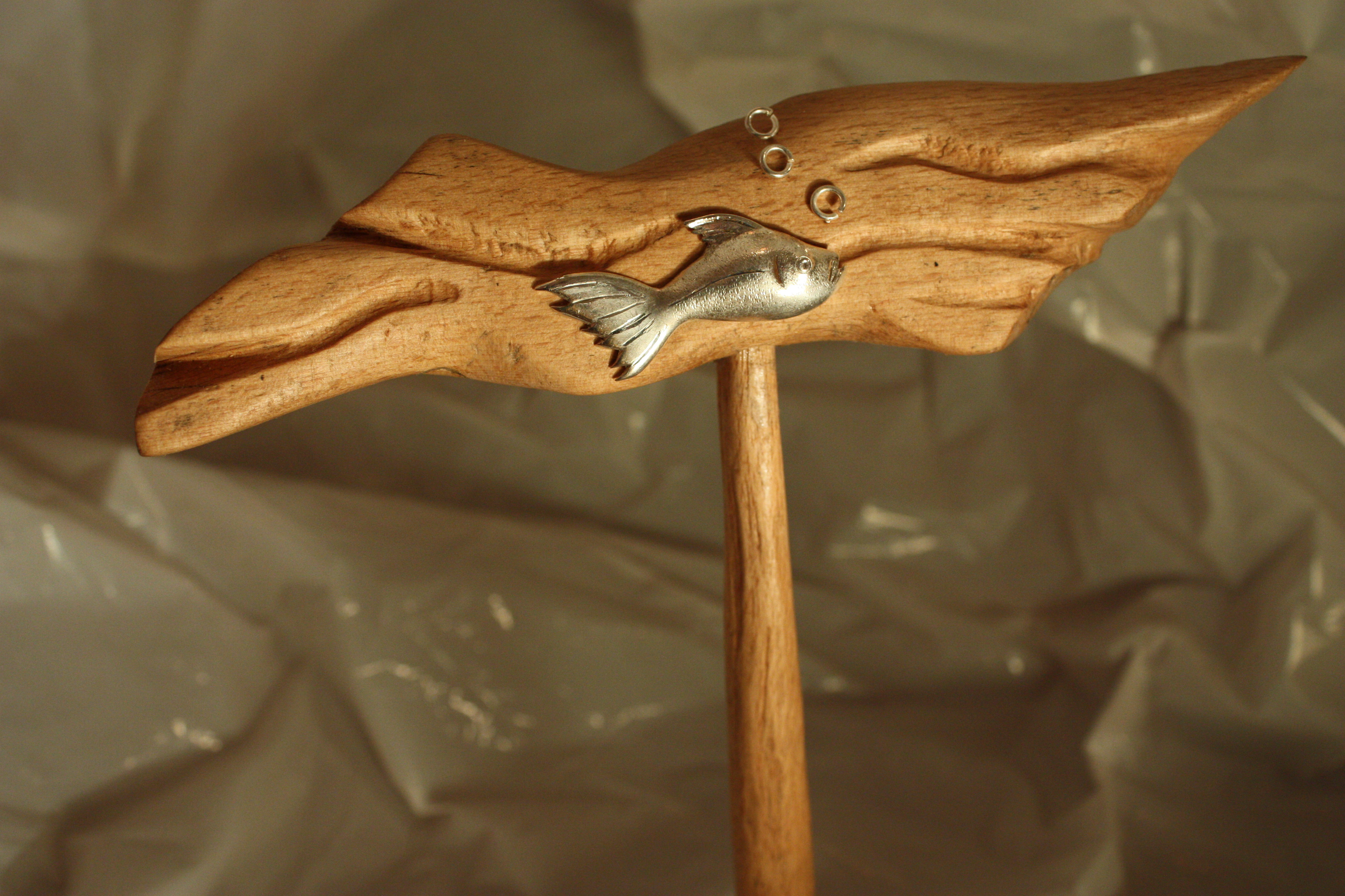 Handmade silver fish on wood