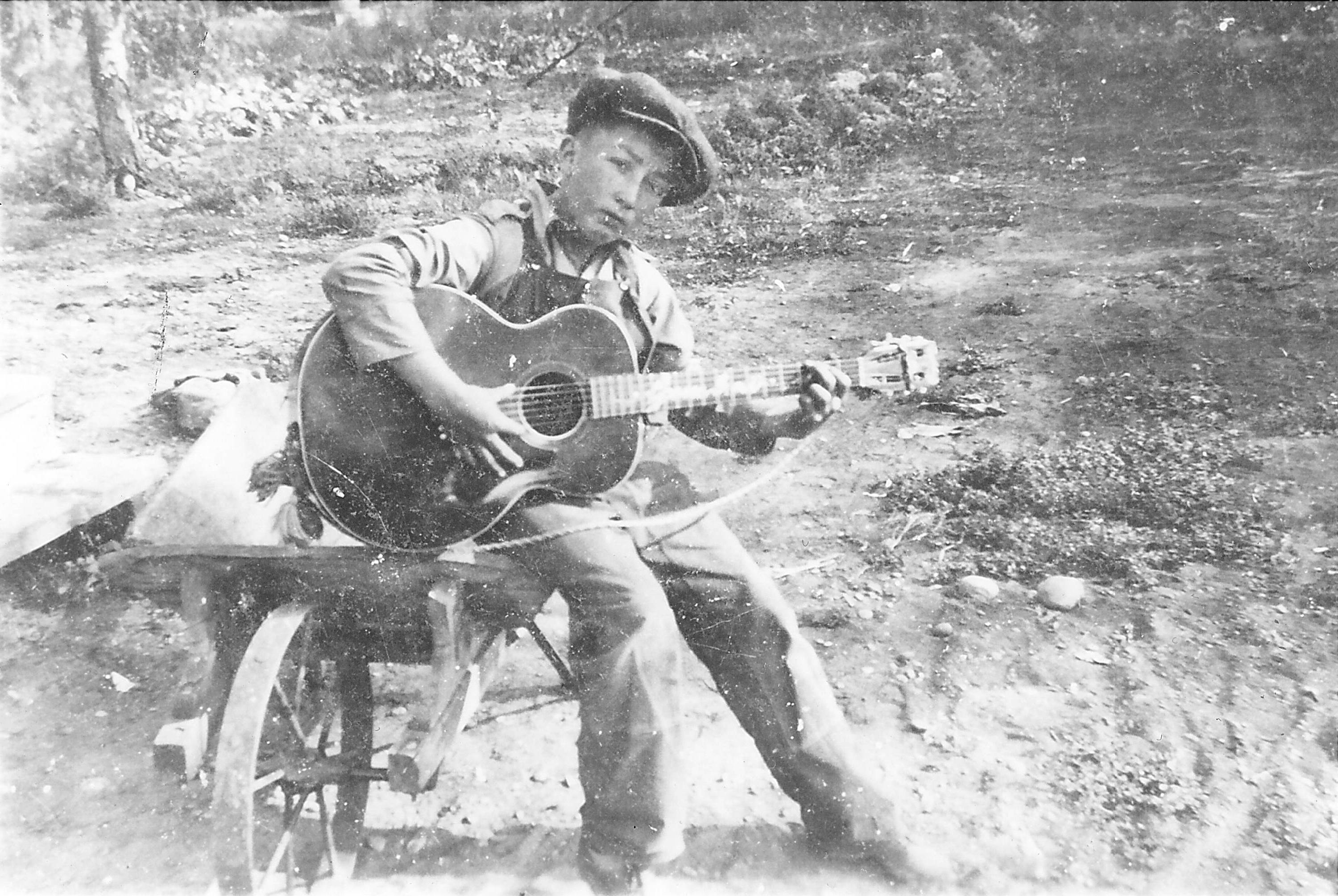 This young gentleman has a suave look about him. Perhaps it comes from his casual stance holding the guitar and perched on the edge of a wheel barrow; or his inquisitive arched brow. In any case we do not have record who this may be- if you have any leads please let us know!
990.4.106.37 / Ward, Vera