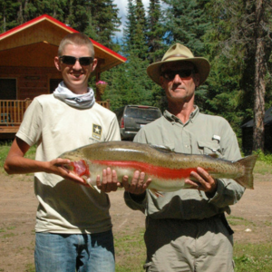 Two Guests Holding a Large Trout