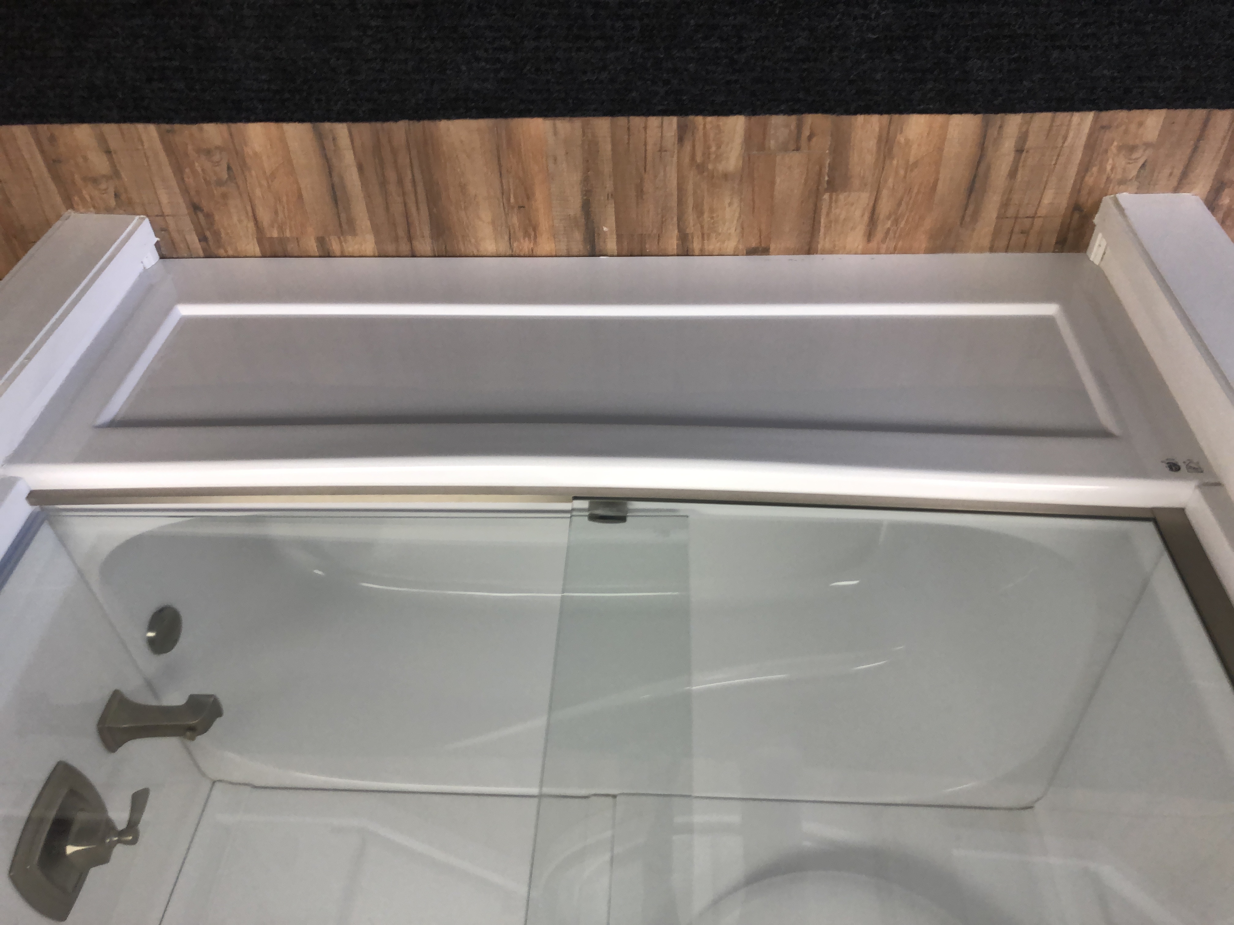 Modern bathroom with a freestanding bathtub, large window, wooden vanity with a vessel sink, potted plant, and floating shelves.