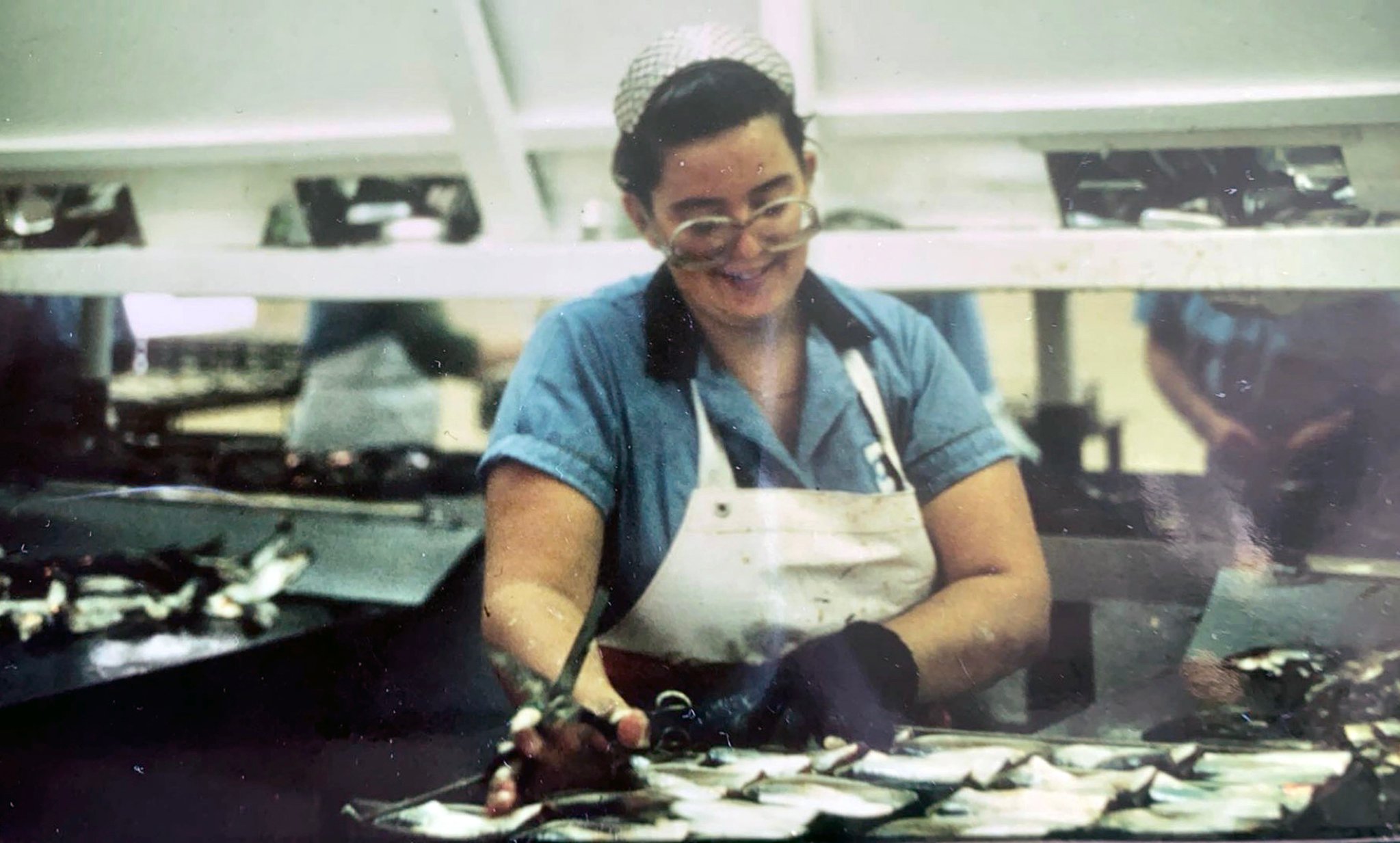 Teri Bainbridge working in the Connors Brothers Seal Cove Sardine Canning Factory, c. 1990.