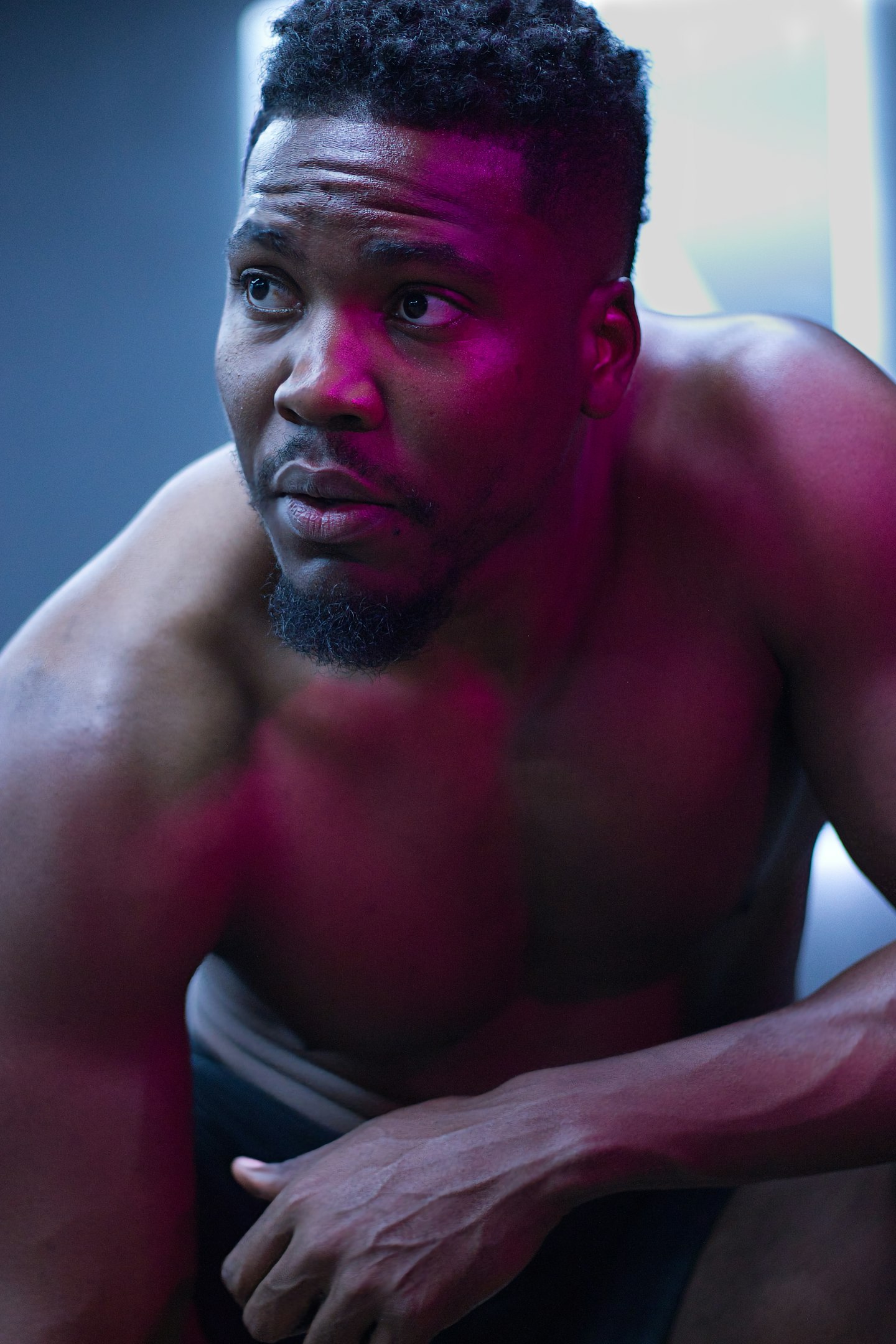 A muscular man stares intently, looking concerned.