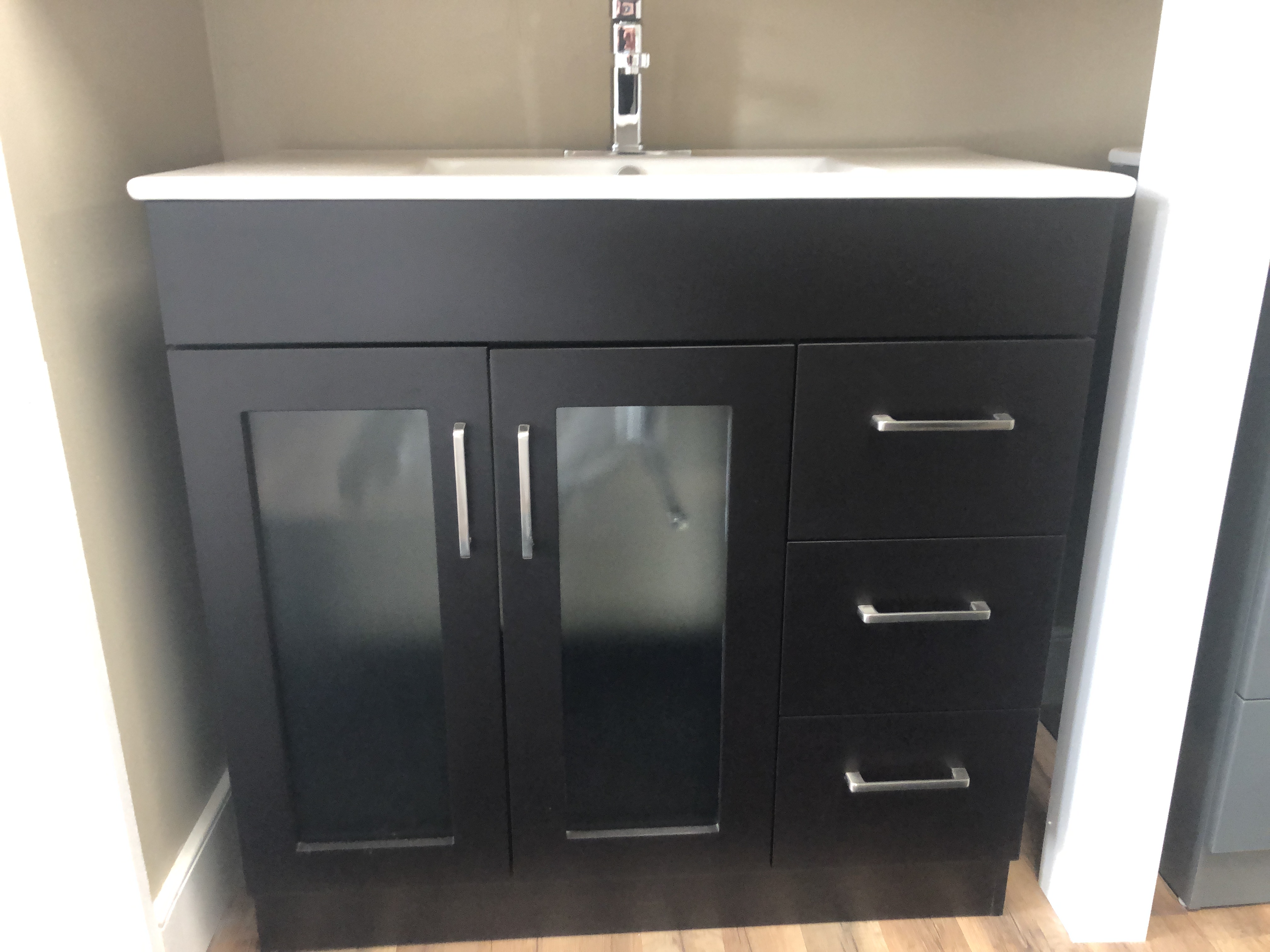 Modern minimalist bathroom with freestanding bathtub, wall-mounted sink, large window, and stylish shelving decor.