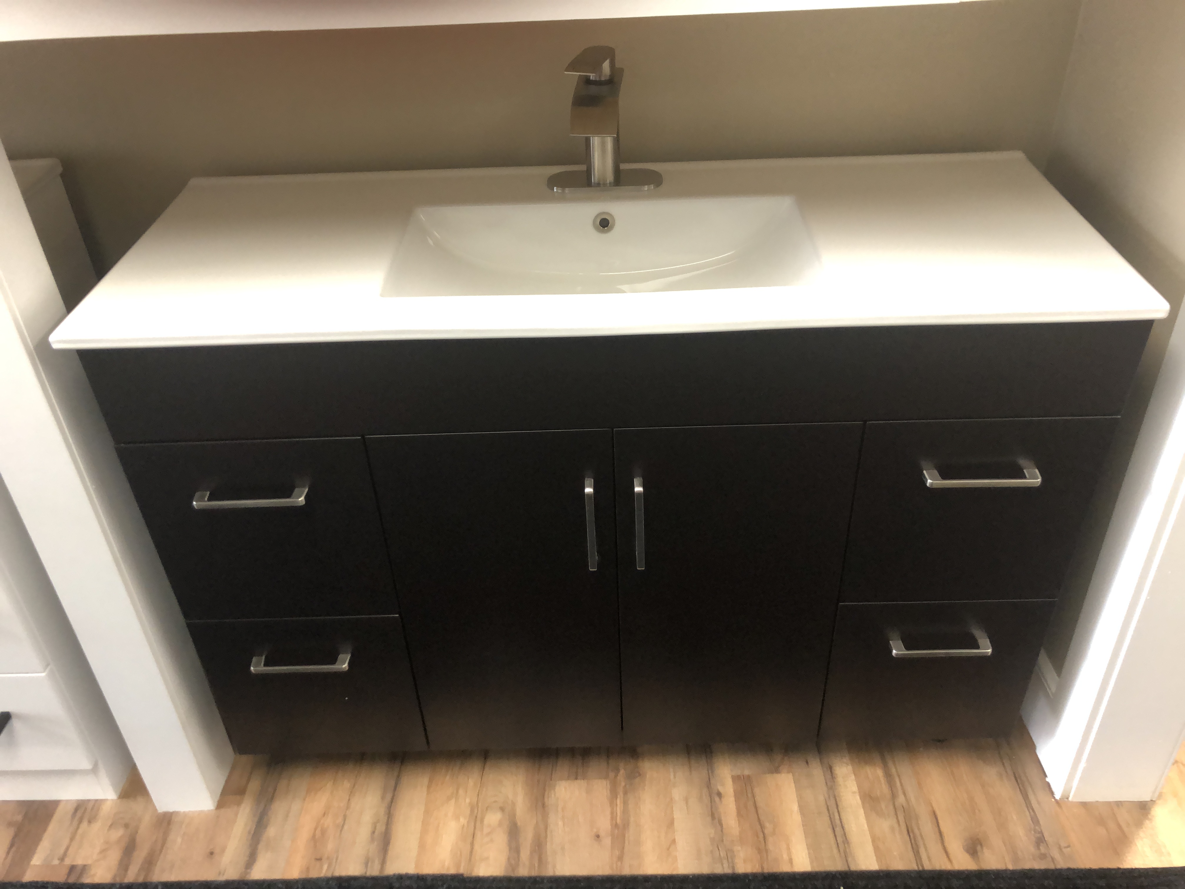 Modern bathroom with freestanding bathtub, round mirror, large window, green plants, and contemporary fixtures.