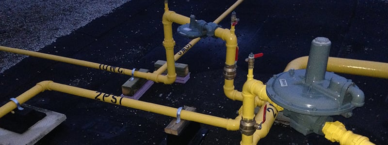 Modern data center interior with server racks and industrial equipment in a bright, spacious room with large windows and a sleek chair.