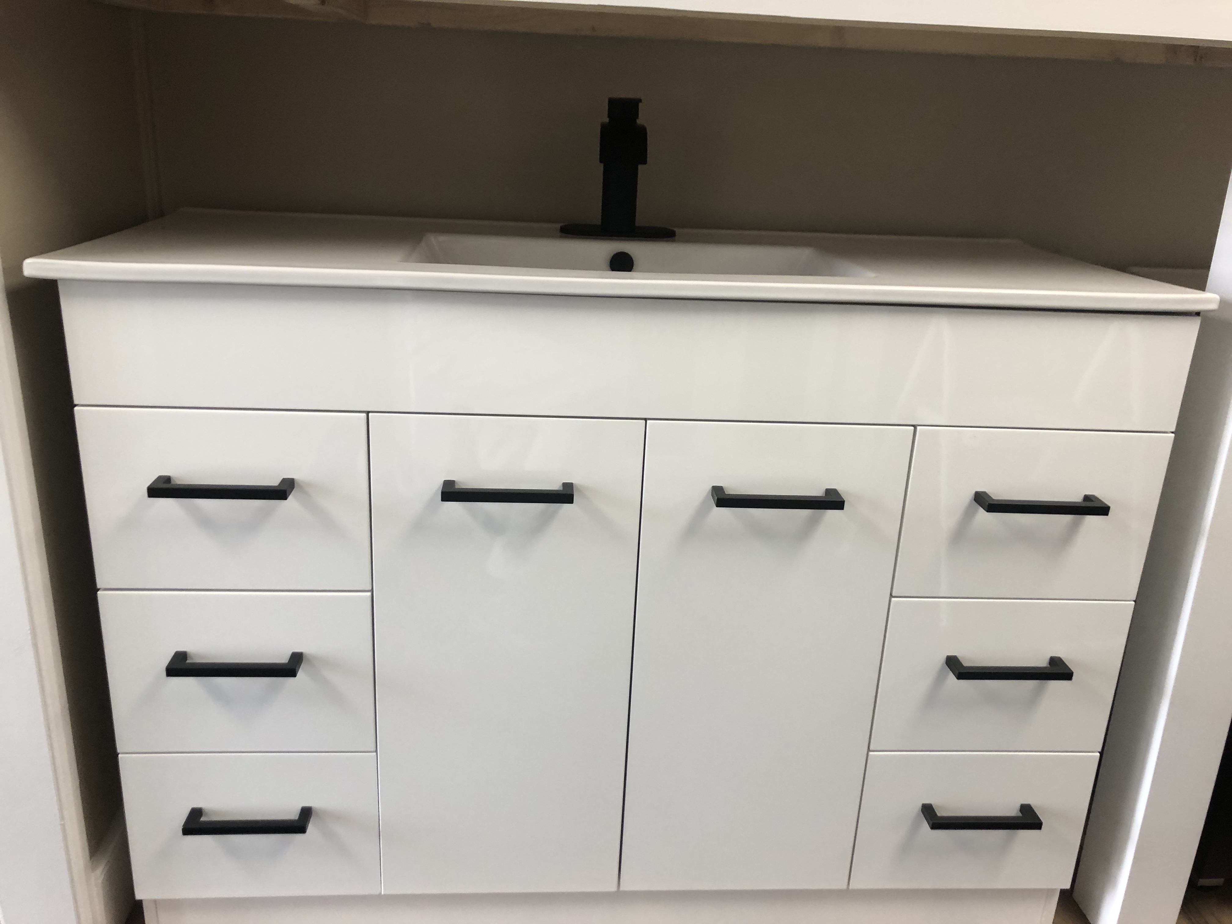 Modern minimalist bathroom with freestanding bathtub, large mirror, indoor plants, and natural light.