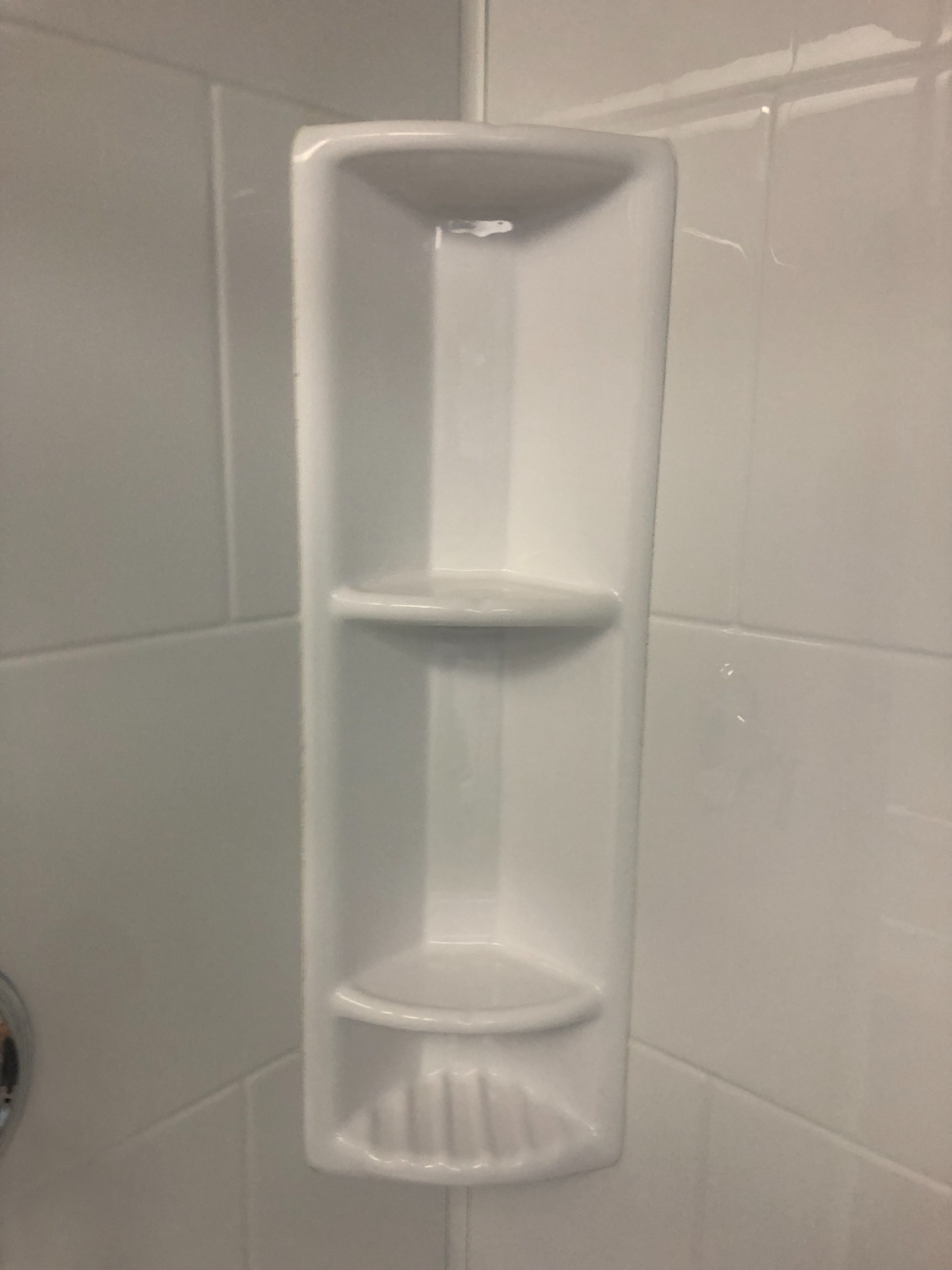 Modern bathroom with freestanding bathtub, sleek fixtures, and wooden accent wall, featuring natural light and potted plants.