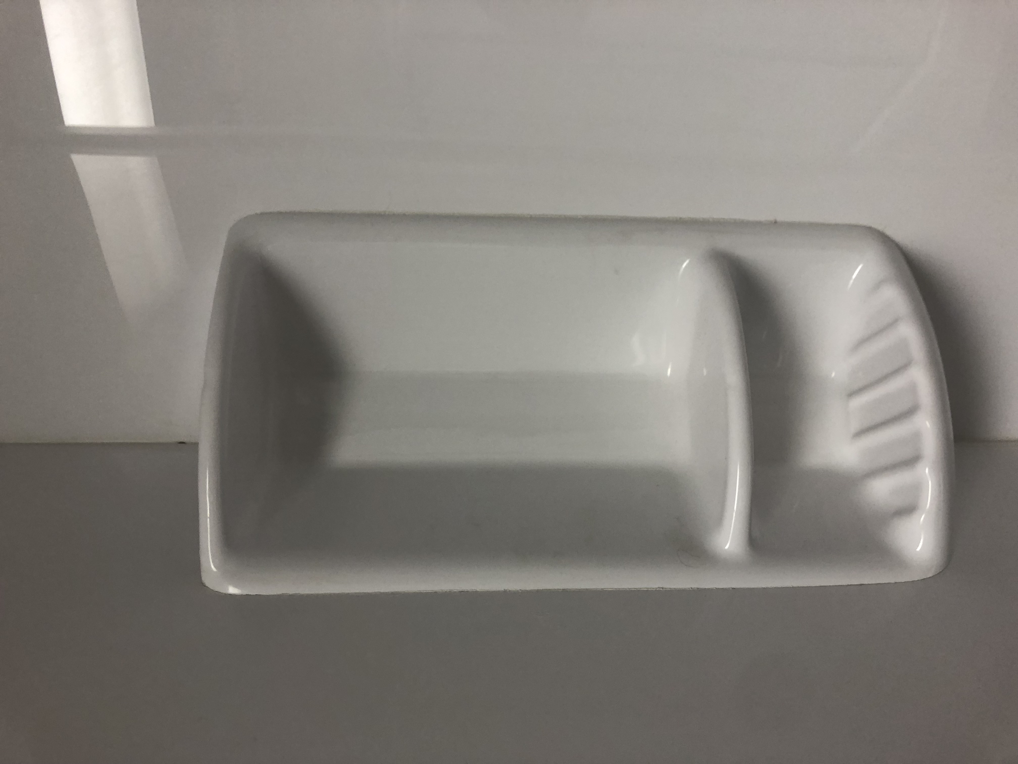 Modern bathroom with glass shower, dual mirrors, two white toilets, and potted plants, featuring minimalist design and large windows for natural light.