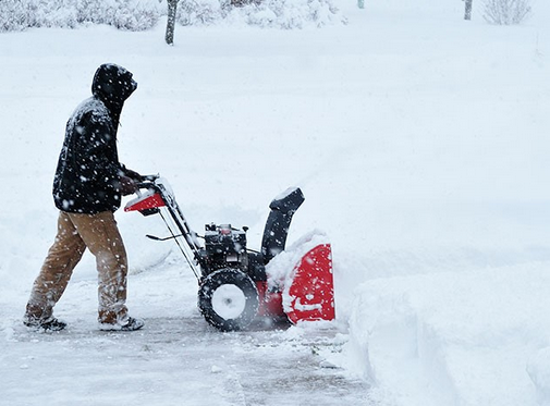 Snowblower Clearing Driveway in Winter Storm