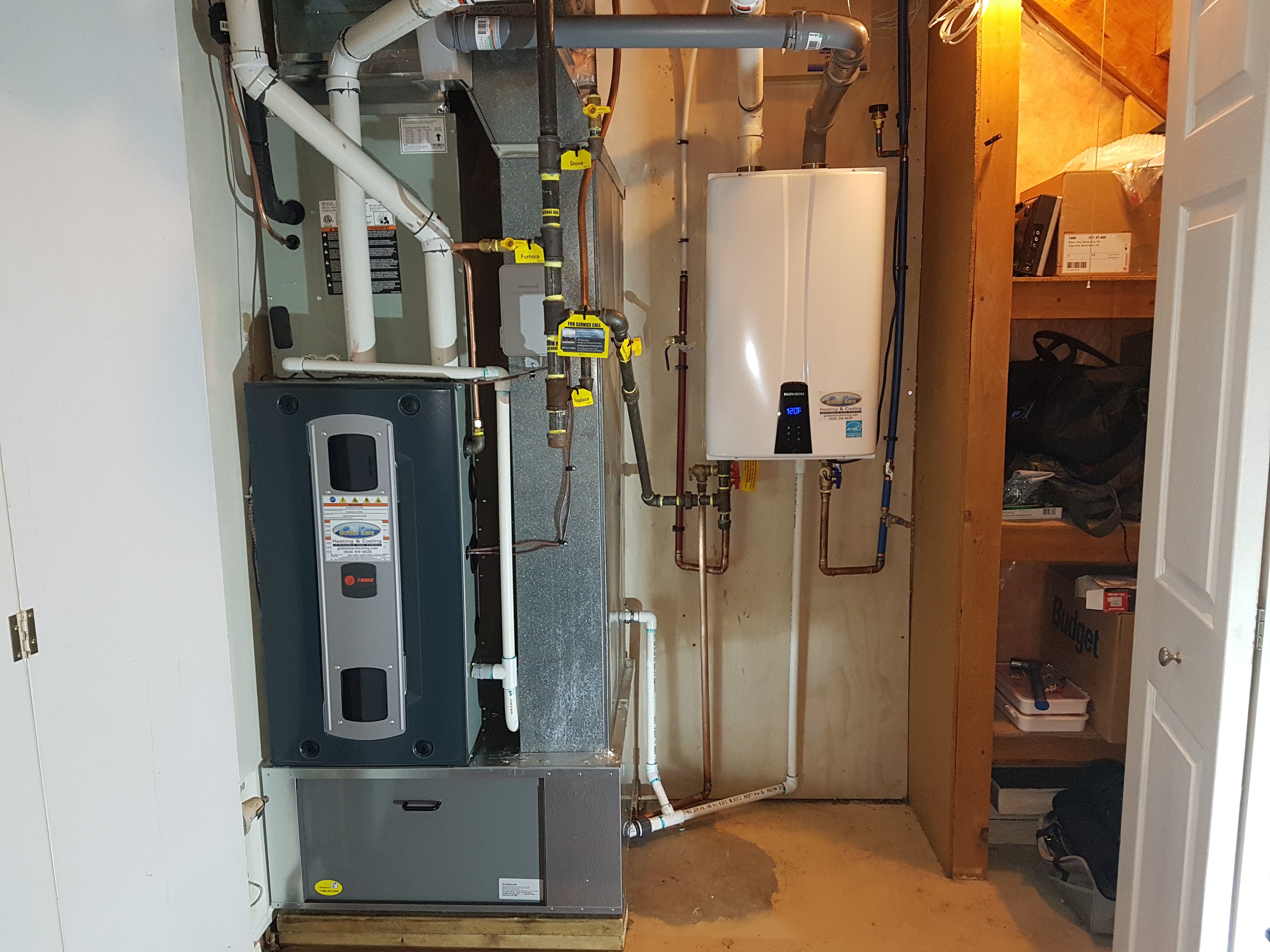 Man in blue shirt reaching into a well-organized kitchen refrigerator in a bright modern kitchen.