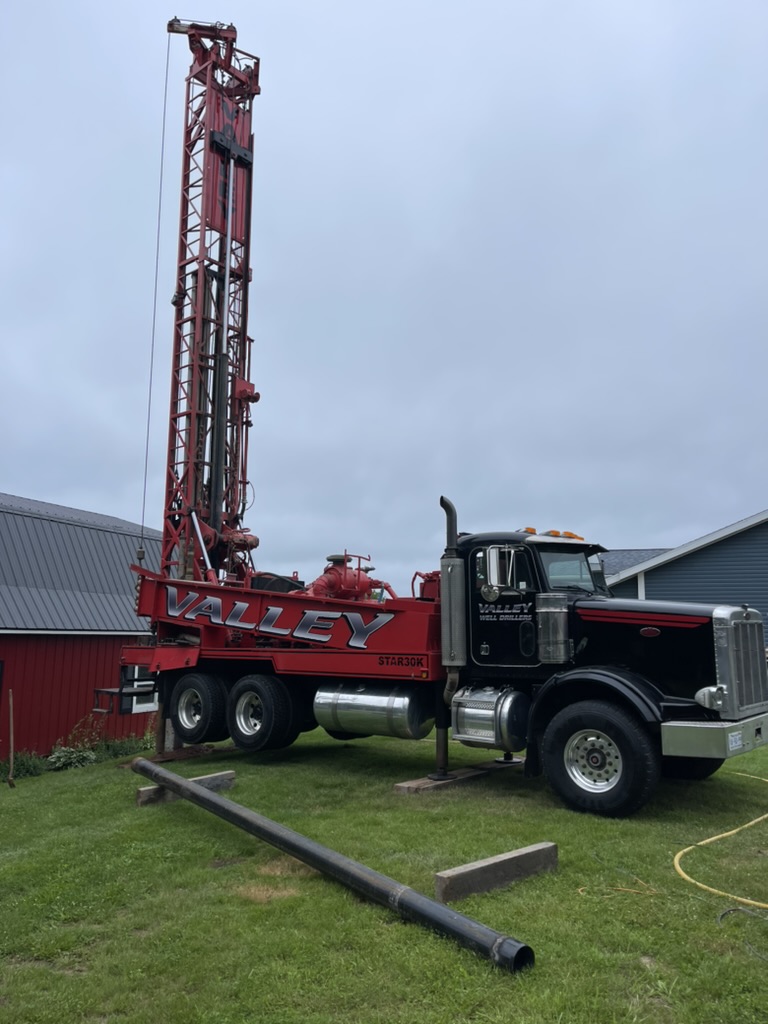 Red and black Valley well drilling truck with large drilling rig. Red and black Valley well drilling truck with large drilling rig.