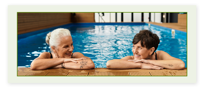 Two women smiling at eachother in a pool