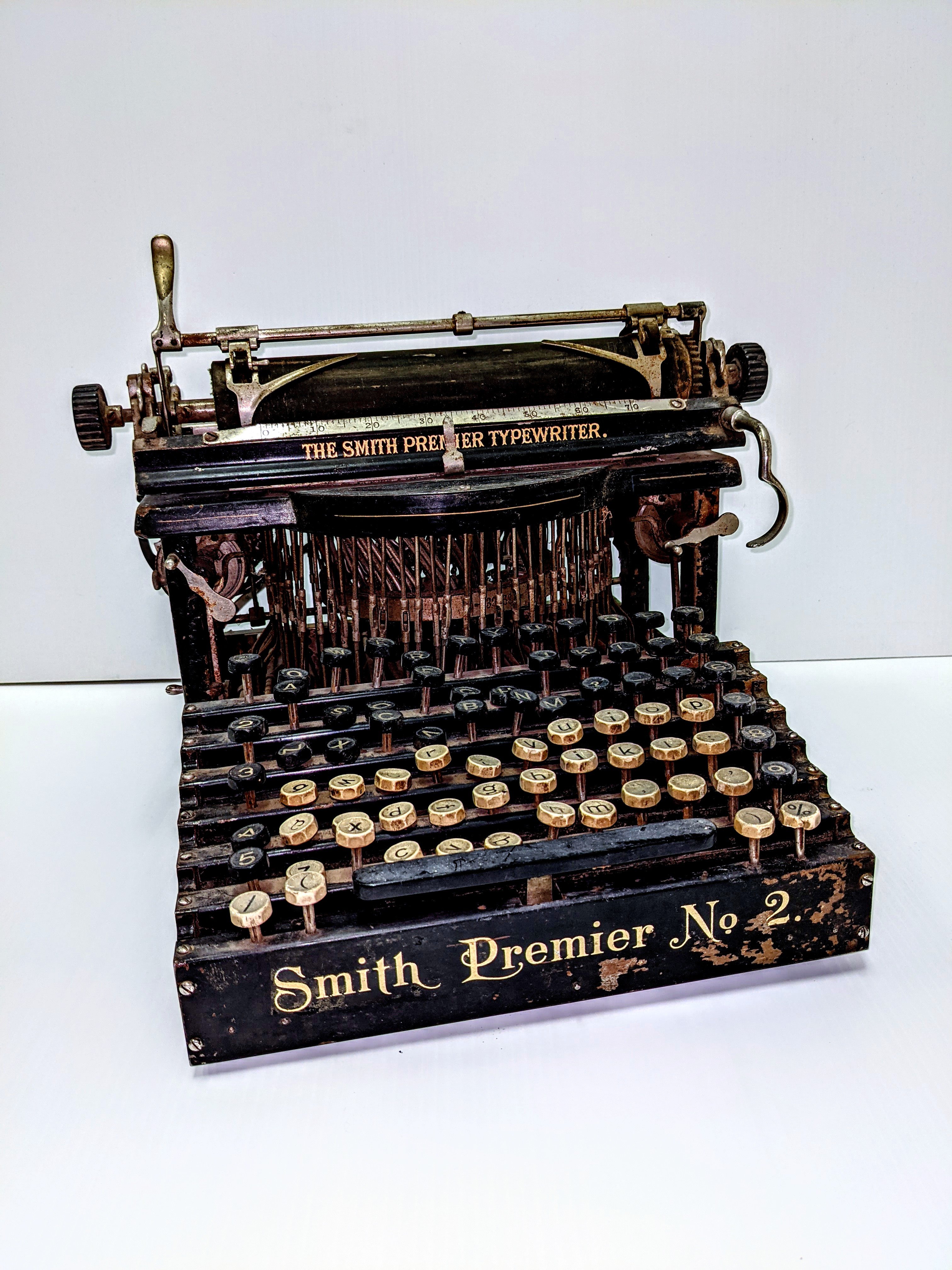 This Smith Premier No 2. Typewriter dates from 1904.  This typewriter has 2 full keyboard sets (one of upper case and one of lowercase) and uses an upstrike mechanism which makes it a 'Blindwriter'. Using this machine the typist cannot see what they are typing until they flip up the page roller mechanism. This differs from the 'modern' or 'visible' typewriter in which the typists sees what they are typing.

Another unique feature is the hand cranked cleaning brush for cleaning the typebars. 

15/03/2021
2004.03.04 / Twidale, John & Alfa