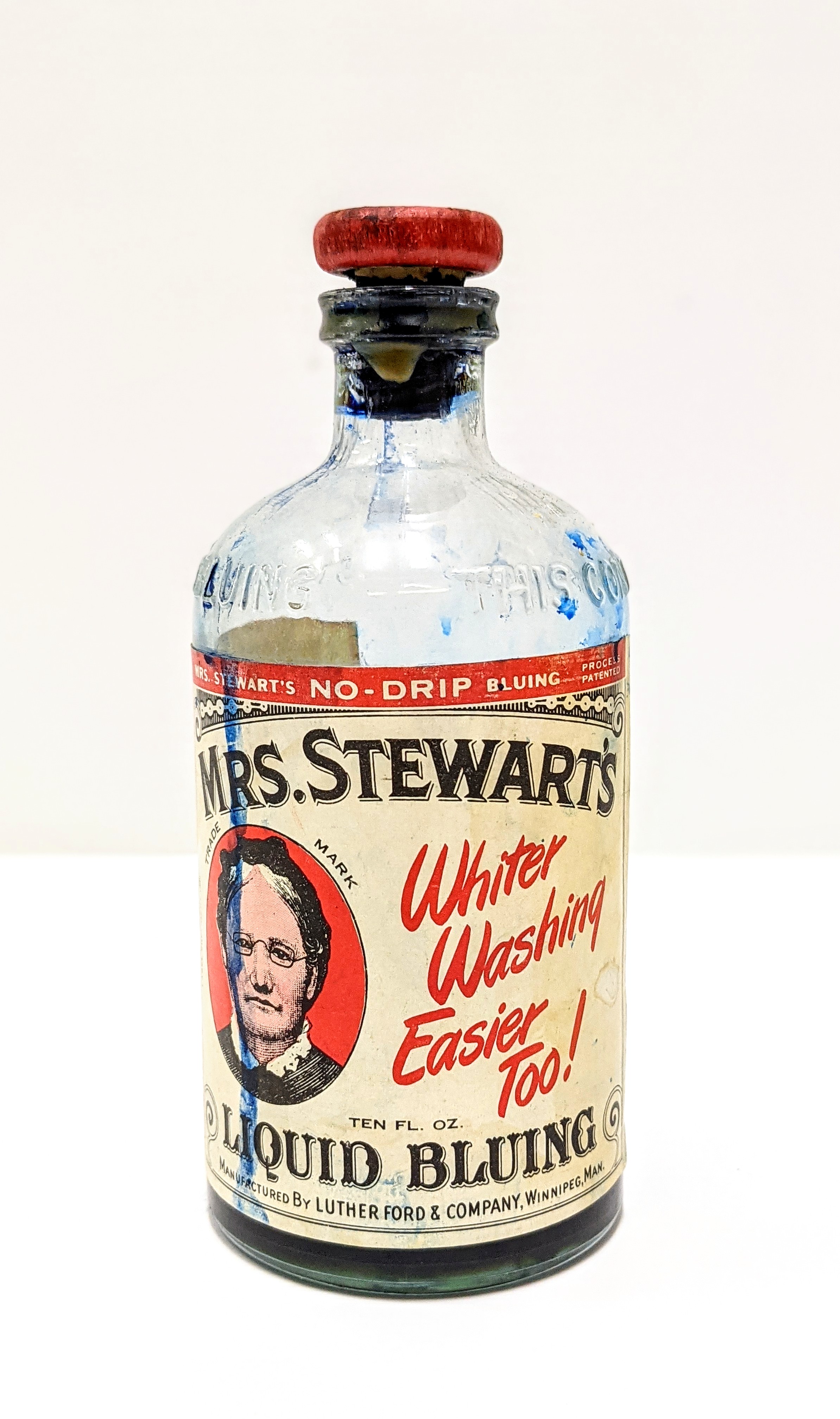 This rich blue liquid was used to help brighten white fabrics from yellow and grey hues brought on by age and repeated washings. The instructions read "Add enough Mrs. Stewart's Bluing to the last rinse to make water light sky-blue". According to color theory, the light-blue water counteracts the warm tones of yellowing fabric- this balances the color at a crisp bright white. The bottle dates back to 1950 and is made at the MSB Winnipeg factory. Mrs. Stewarts Bluing dates back to the 1880's and is still available today.

26/04/2021
998.2.7 / Cranna Toews, Marilee