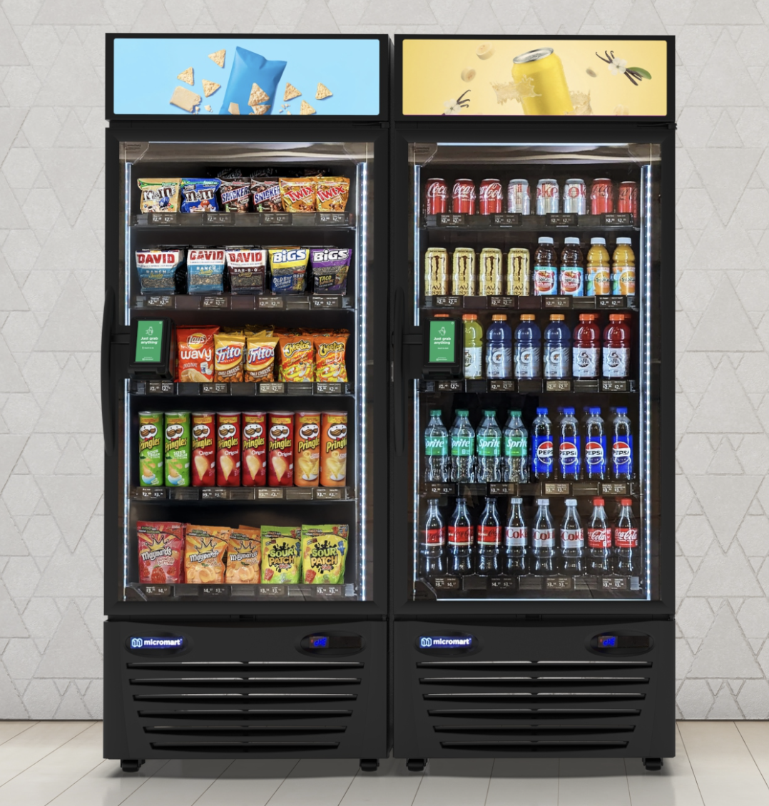 Table de cuisine avec boissons gazeuses en bouteilles, gobelet de jus bleu, canette de boisson jaune, accompagnés de biscuits apéritifs dans un bol et sur une planche en bois, décor moderne avec plantes en arrière-plan.