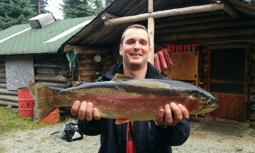 Man in a Black Coat Holding His Catch
