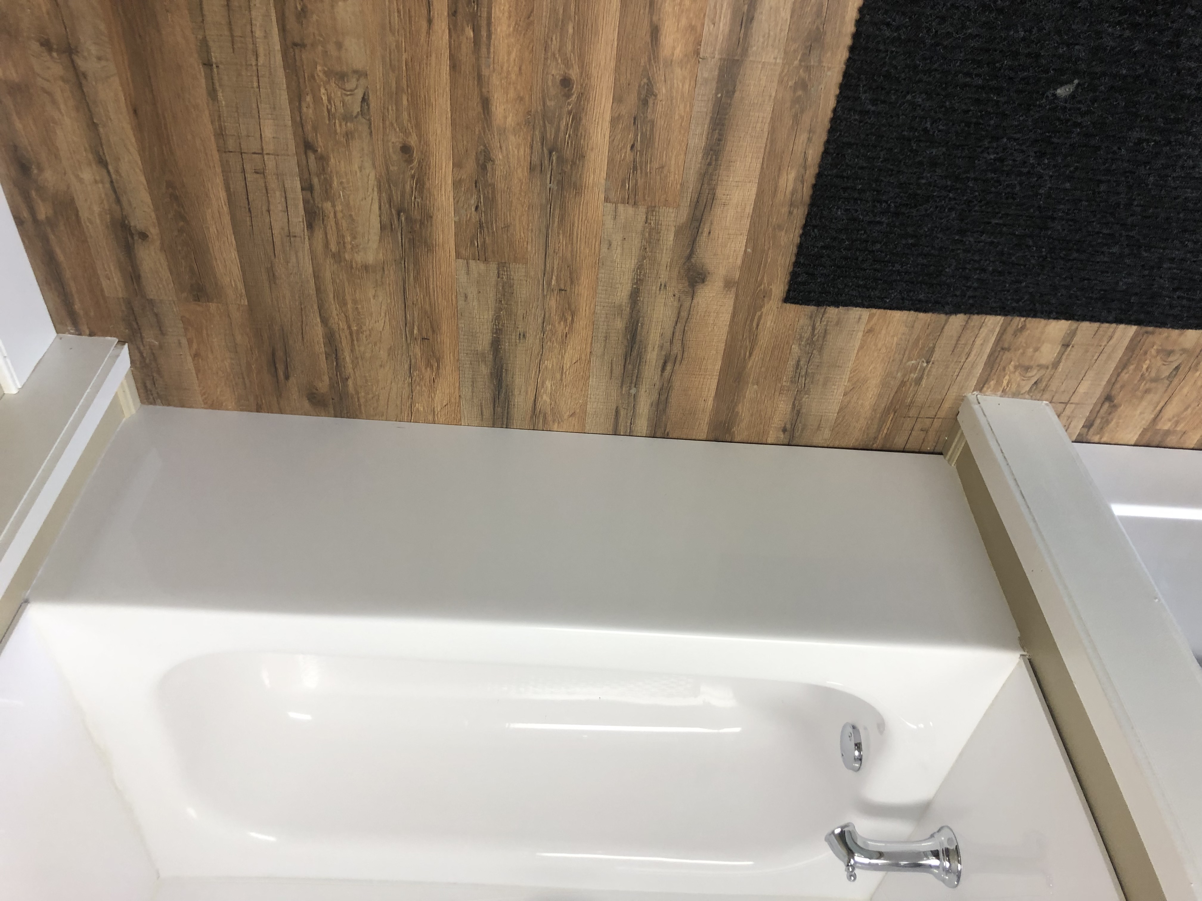 Modern bathroom with large window, wall-mounted vanity with sink, toilet, and decorative plants.