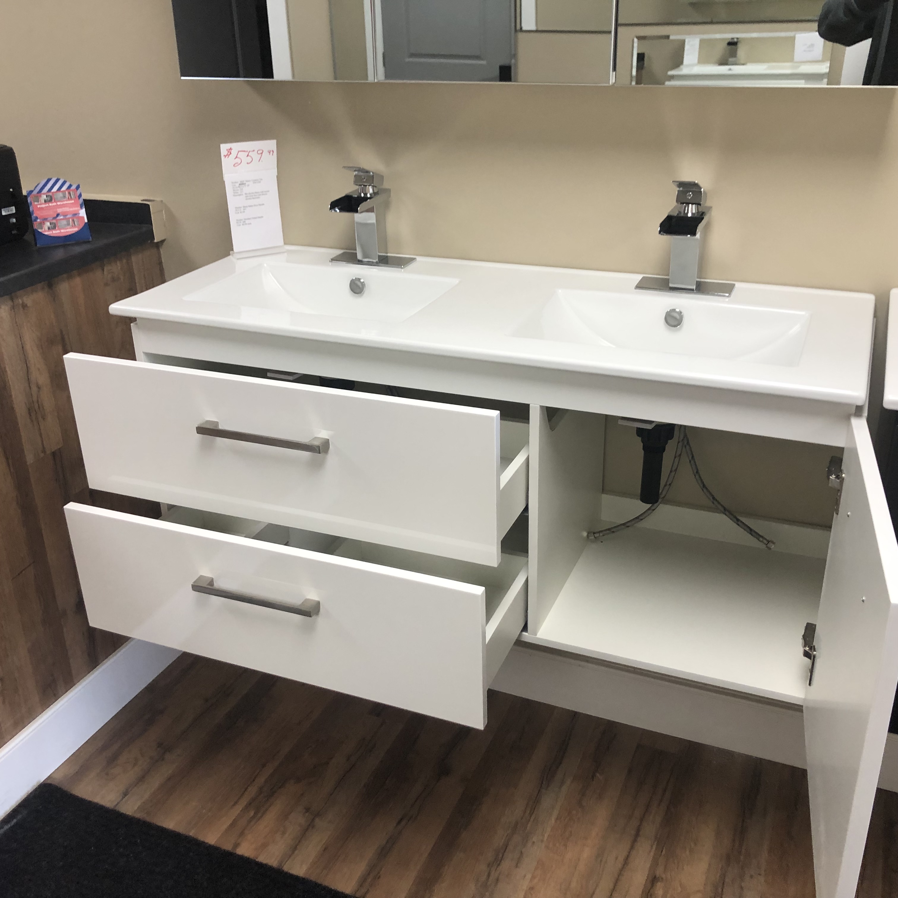 Modern bathroom with freestanding bathtub, glass shower, and vanity with double sinks, accented by potted plants and natural light through a large window.