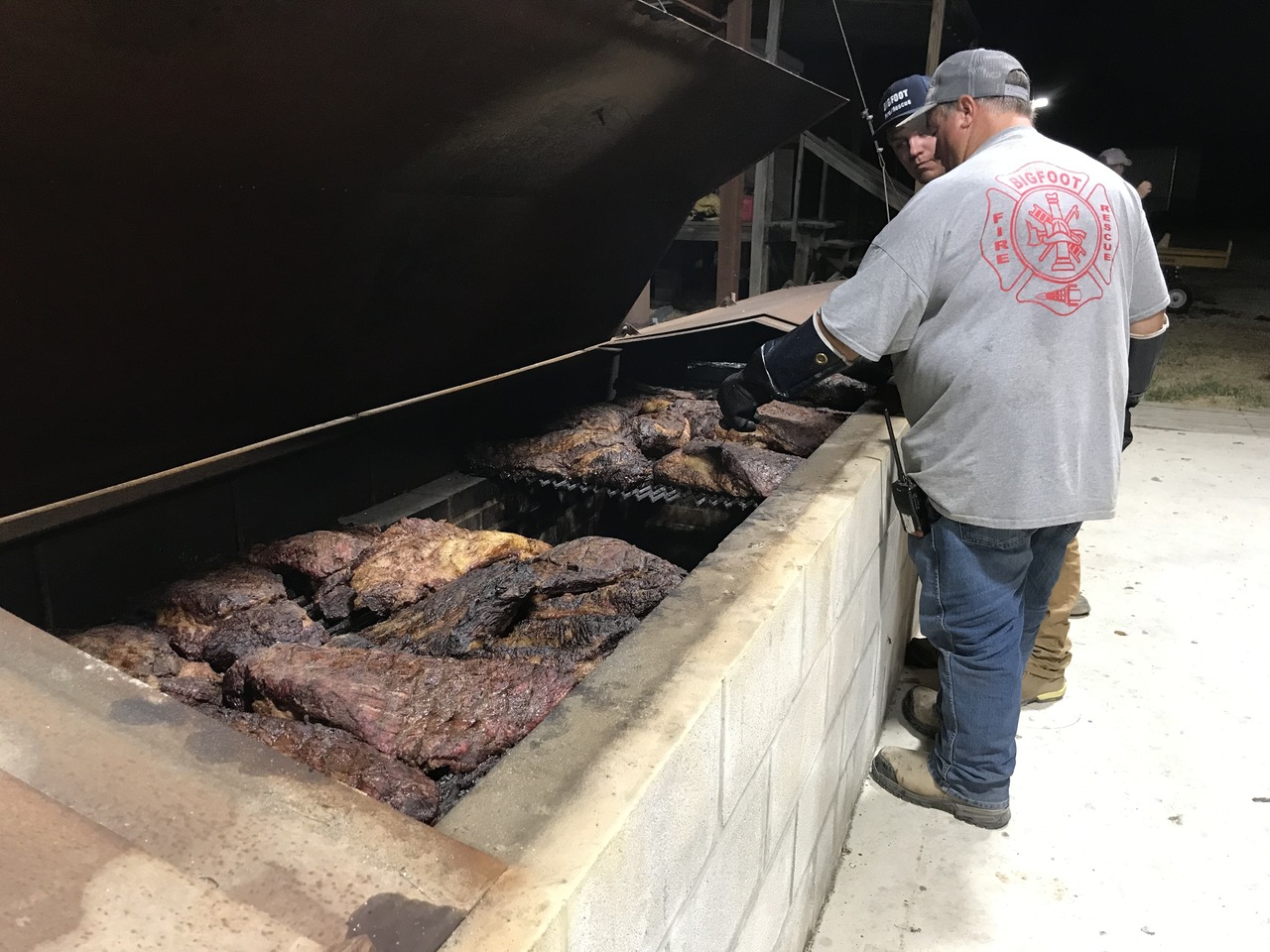 Two of our VFD chefs working briskets on  the barbecue pit.