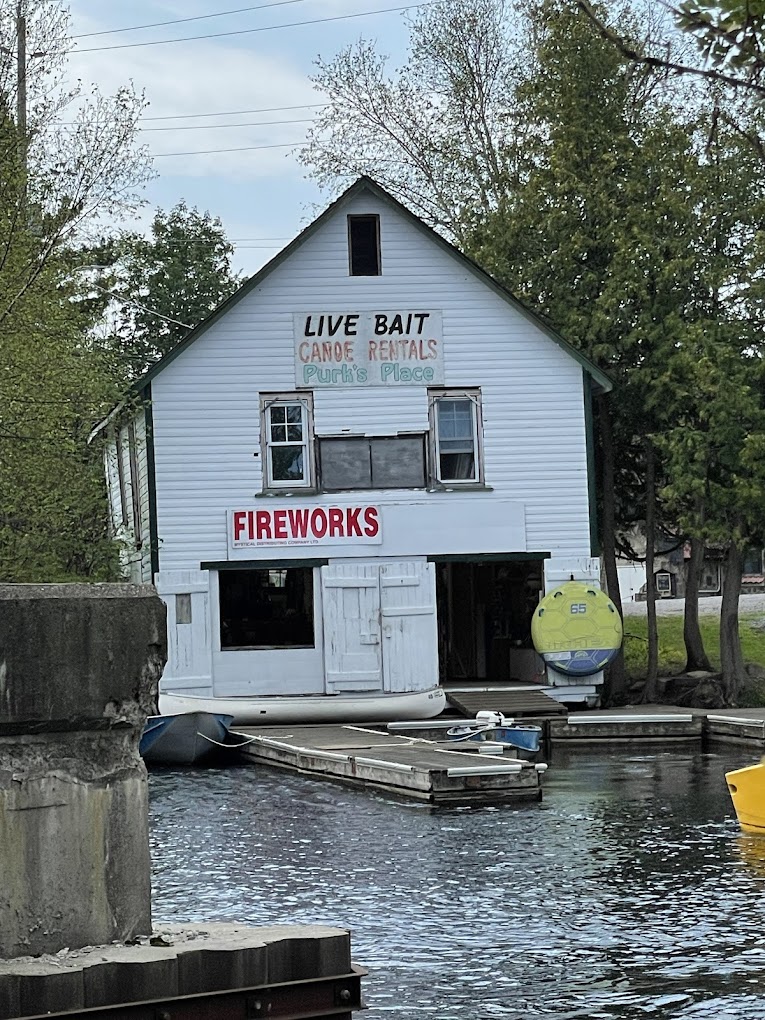 Rustic riverside boathouse with a wooden dock and small motorboat, surrounded by scenic mountains and lake. Rustic riverside boathouse with a wooden dock and small motorboat, surrounded by scenic mountains and lake.