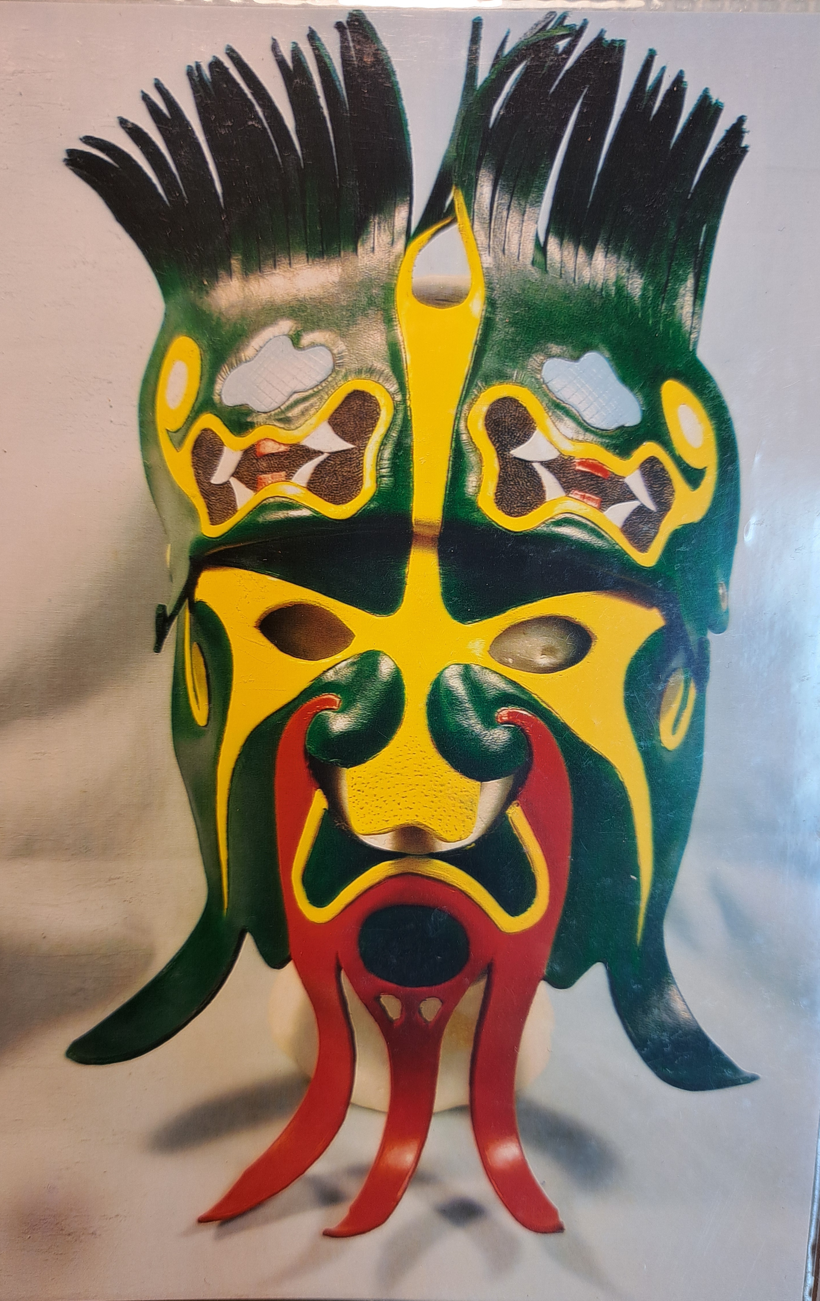 A detailed custom leather mask with yellow, green, and red details.