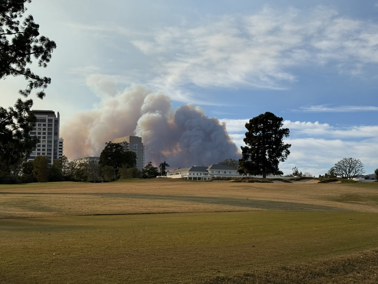 Dramatic forest fire scene with large flames and smoke rising over a serene lake surrounded by trees at sunset. Dramatic forest fire scene with large flames and smoke rising over a serene lake surrounded by trees at sunset.
