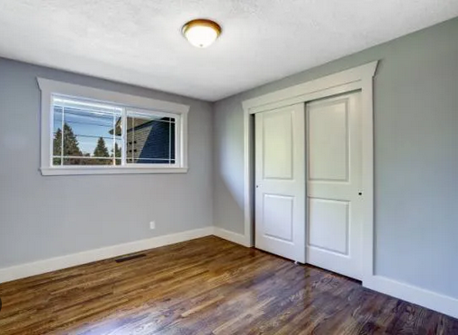Freshly Painted Bedroom with Hardwood Floors and White Trim