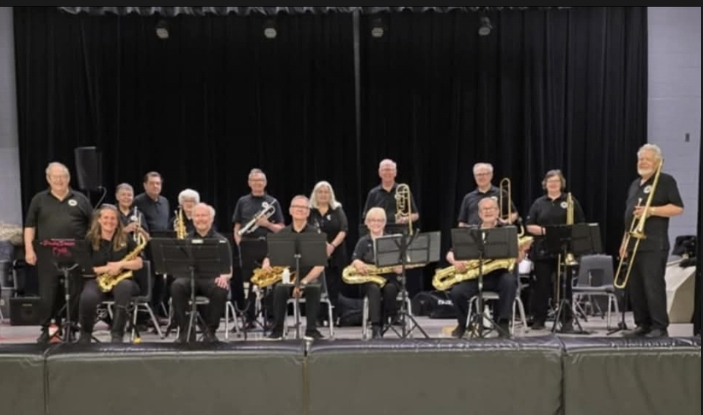 Lakeshore Show Band members sitting on a stage with their instruments
