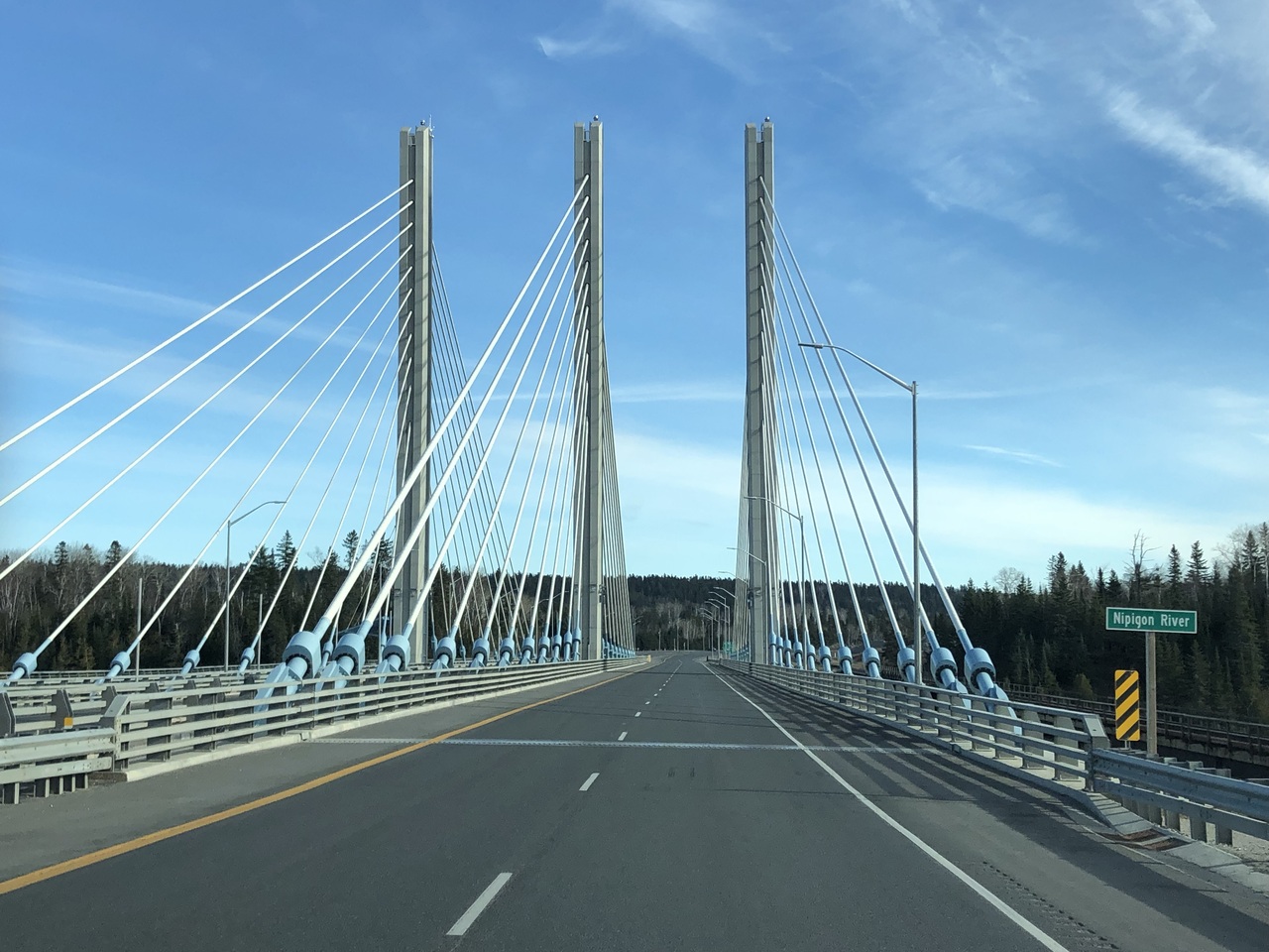 Close-up of a worker welding metal bars with bright sparks in an industrial factory setting.