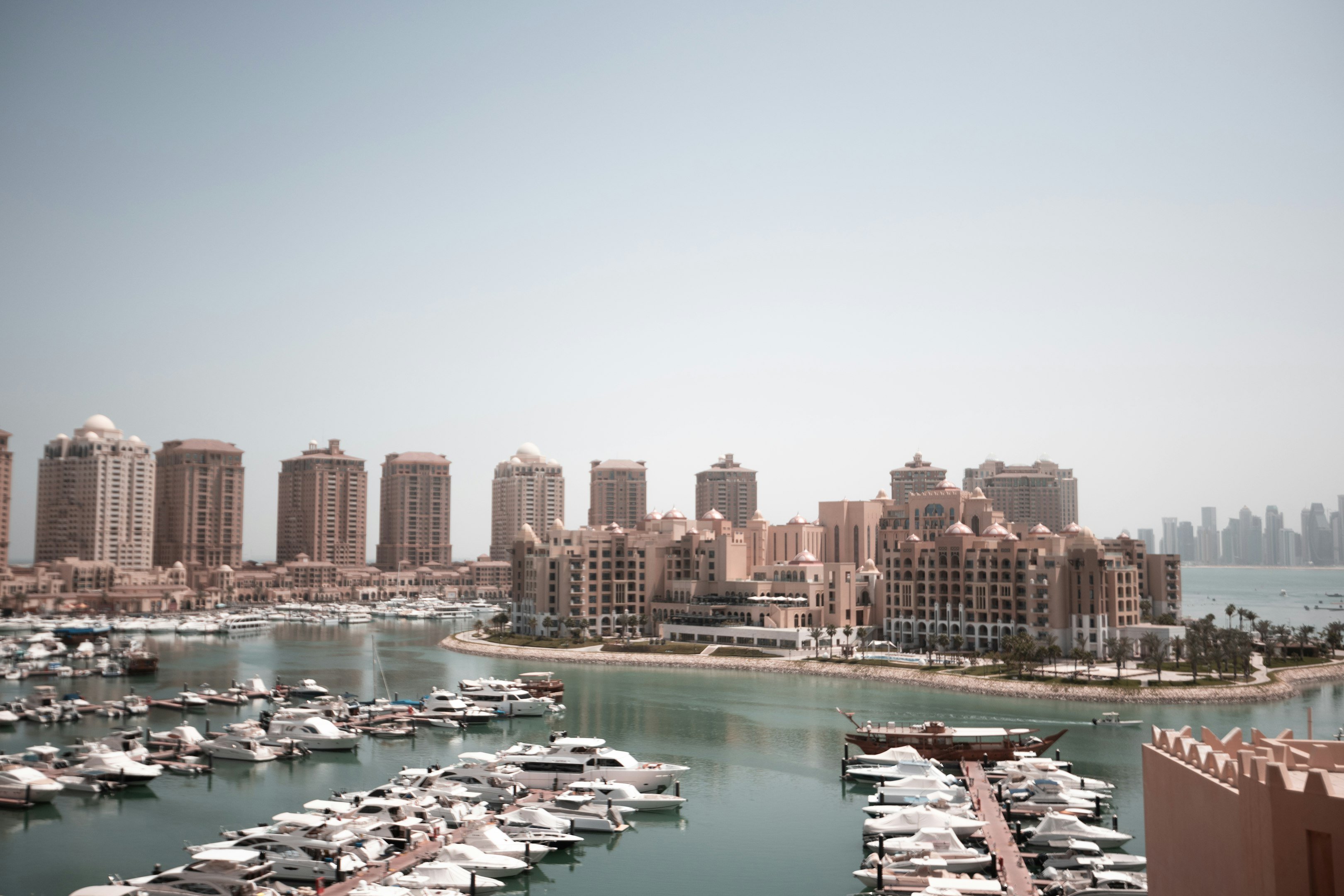 a harbor filled with lots of boats next to tall buildings