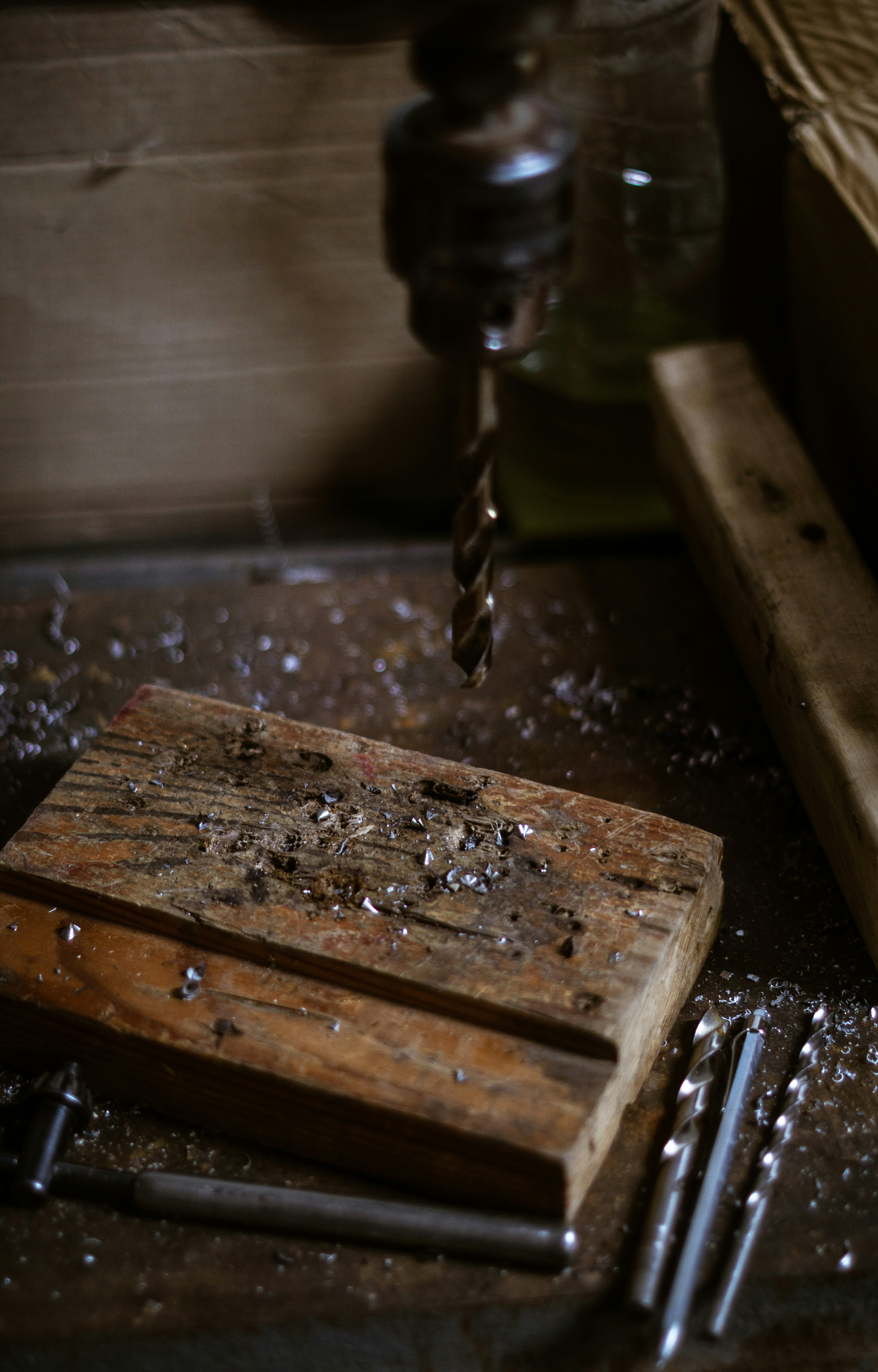 Drill press with wood shavings and drill bits