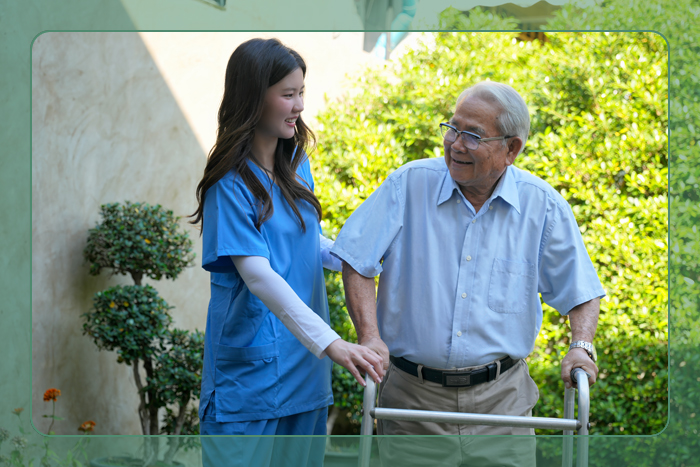 A caregiver assisting an elderly man to walk