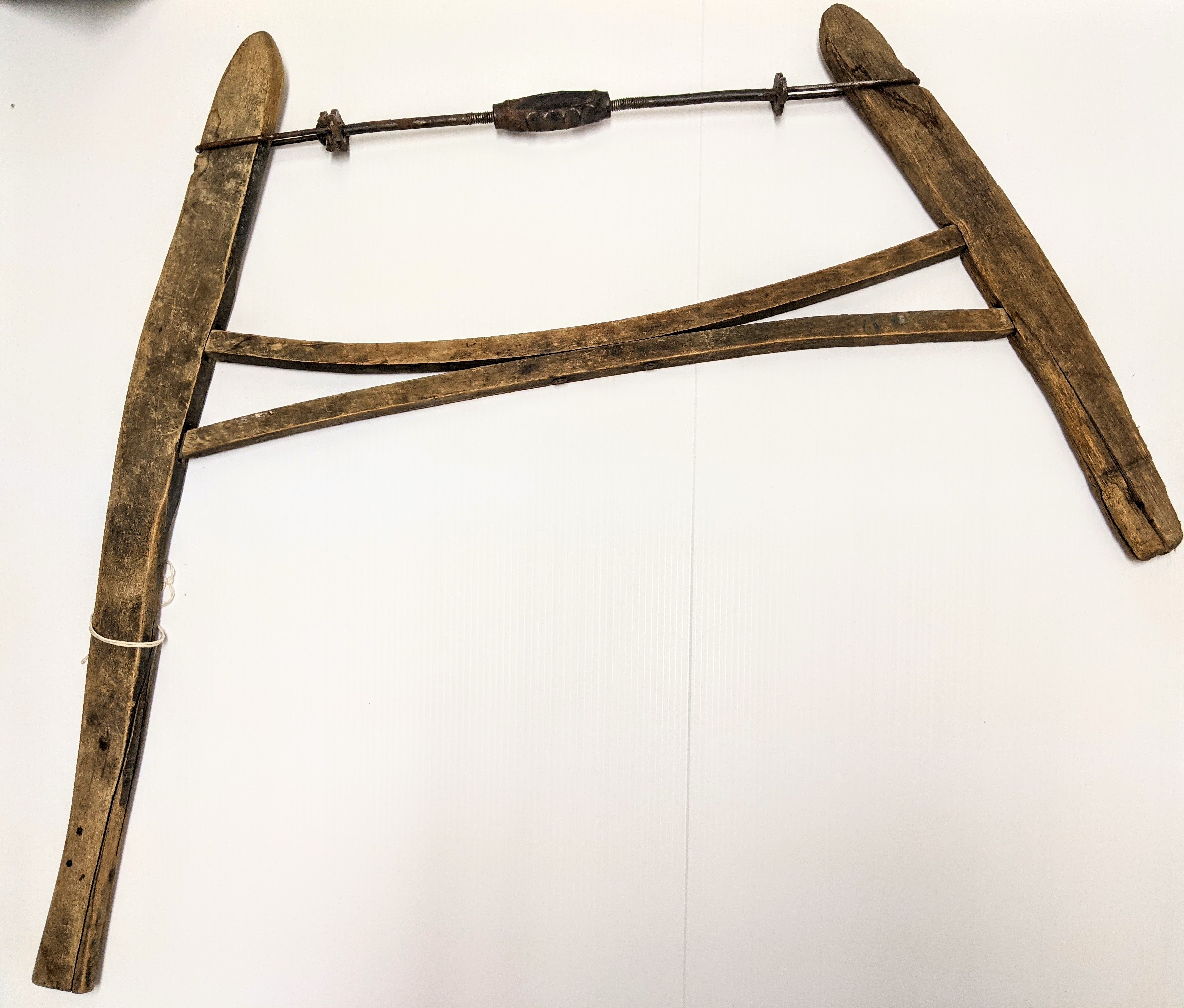 Commonly referred to as a "bow saw" or "buck saw" this wooden apparatus was a staple in Fort Vermilion life. It was this type of saw that was used for slicing up logs into manageable chunks which then could be split and used as fire wood. Designed for use by one person, the blades of this saw could be easily replaced and the user could change the style of blade based on the task at hand. It was a very useful tool in everything from collecting firewood, - to building furniture for the home. The longer arm on the left allows the user to grip above and below the blade of the saw - which is missing on this one.
996.40.130 / Eek Marilyn