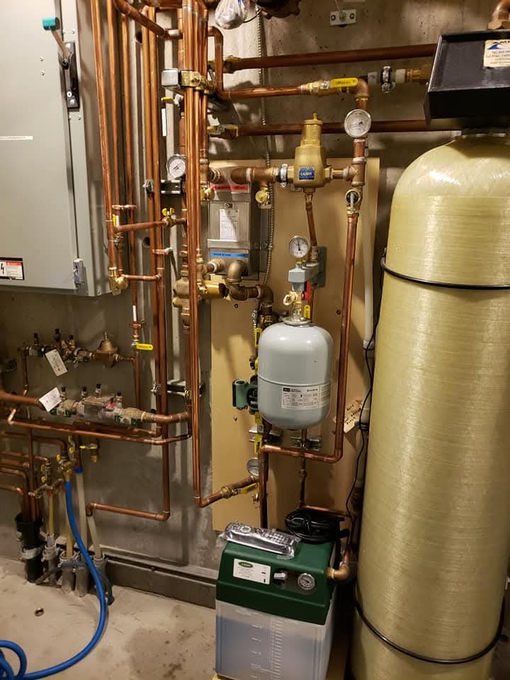 Modern living room with large windows, indoor plants, a cozy sofa, and an air conditioner unit. Modern living room with large windows, indoor plants, a cozy sofa, and an air conditioner unit.