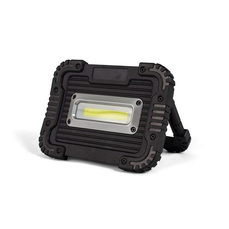 Two glasses of amber beer next to a bottle on a wooden bar counter in a dimly lit pub setting.