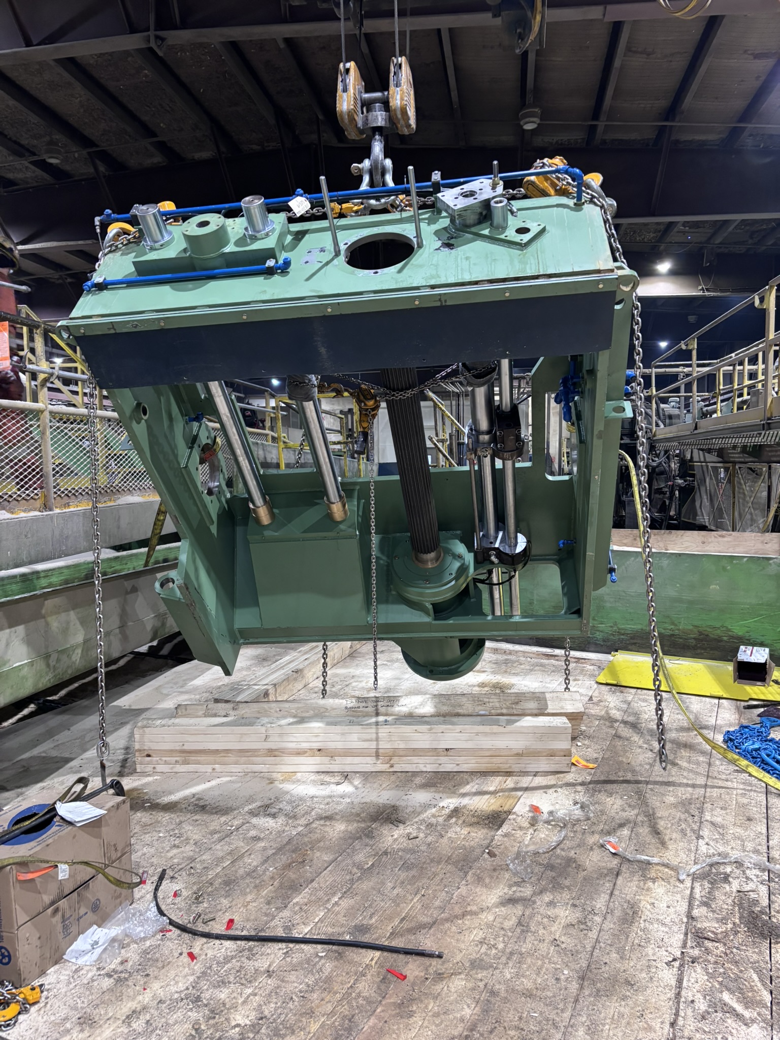Interior of an automotive workshop with blue pickup truck and yellow tow truck, surrounded by tools and equipment.