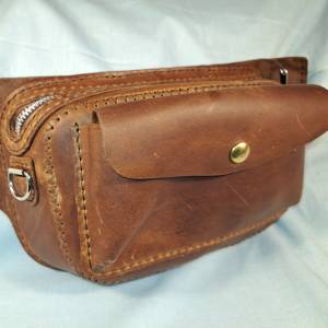 Small brown leather bag with zipper and front button